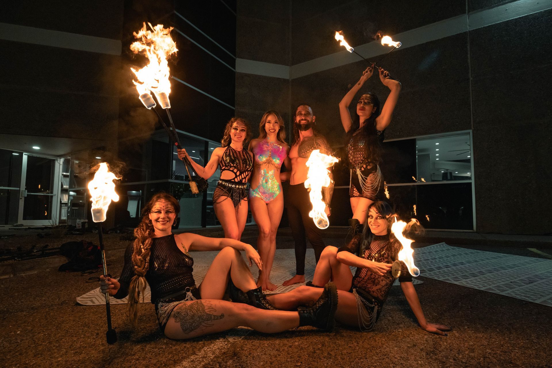 A group of people are posing for a picture while holding fire torches.