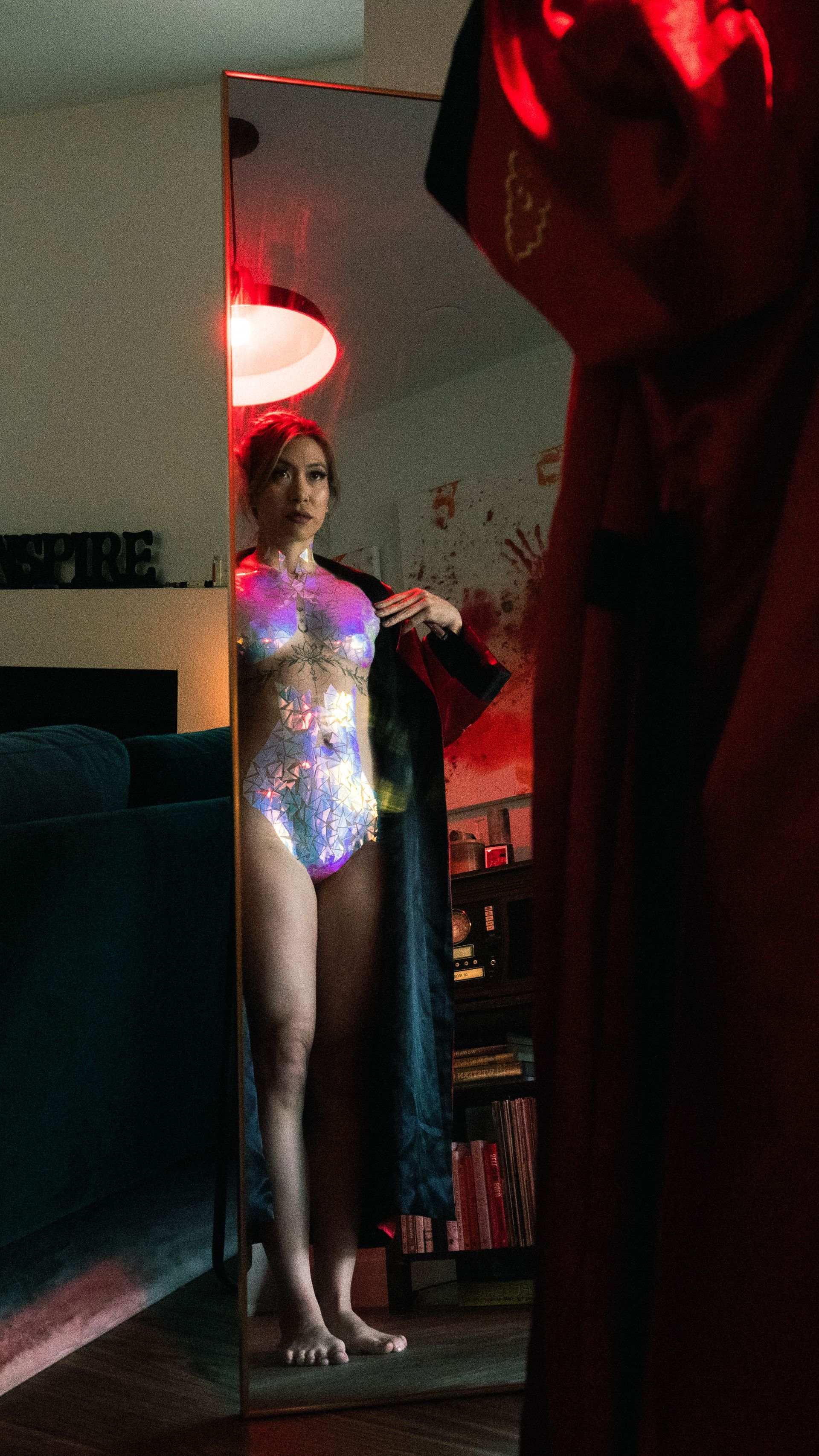 A woman in a bathing suit is standing in front of a mirror.