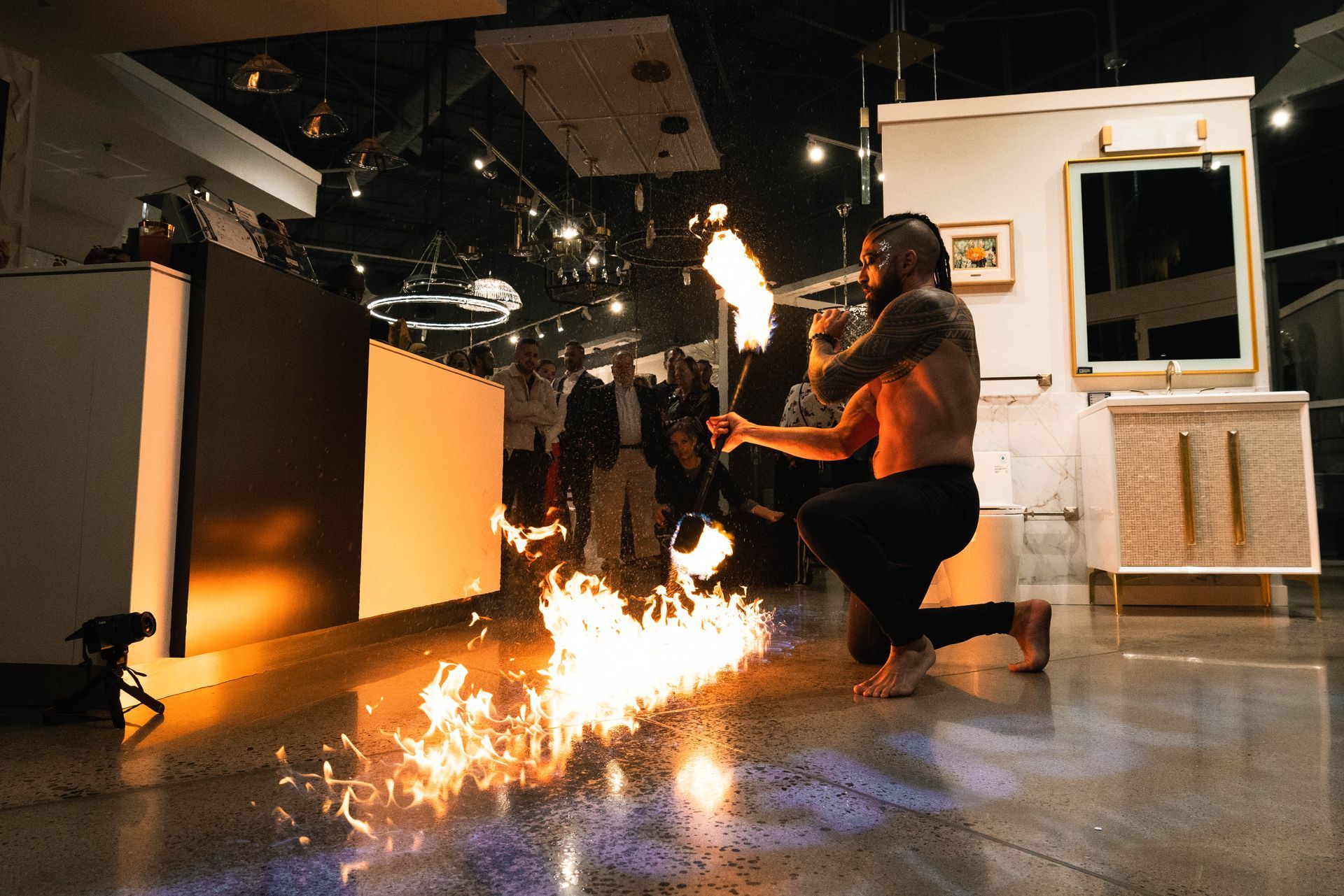 A man is kneeling down in front of a fire torch.