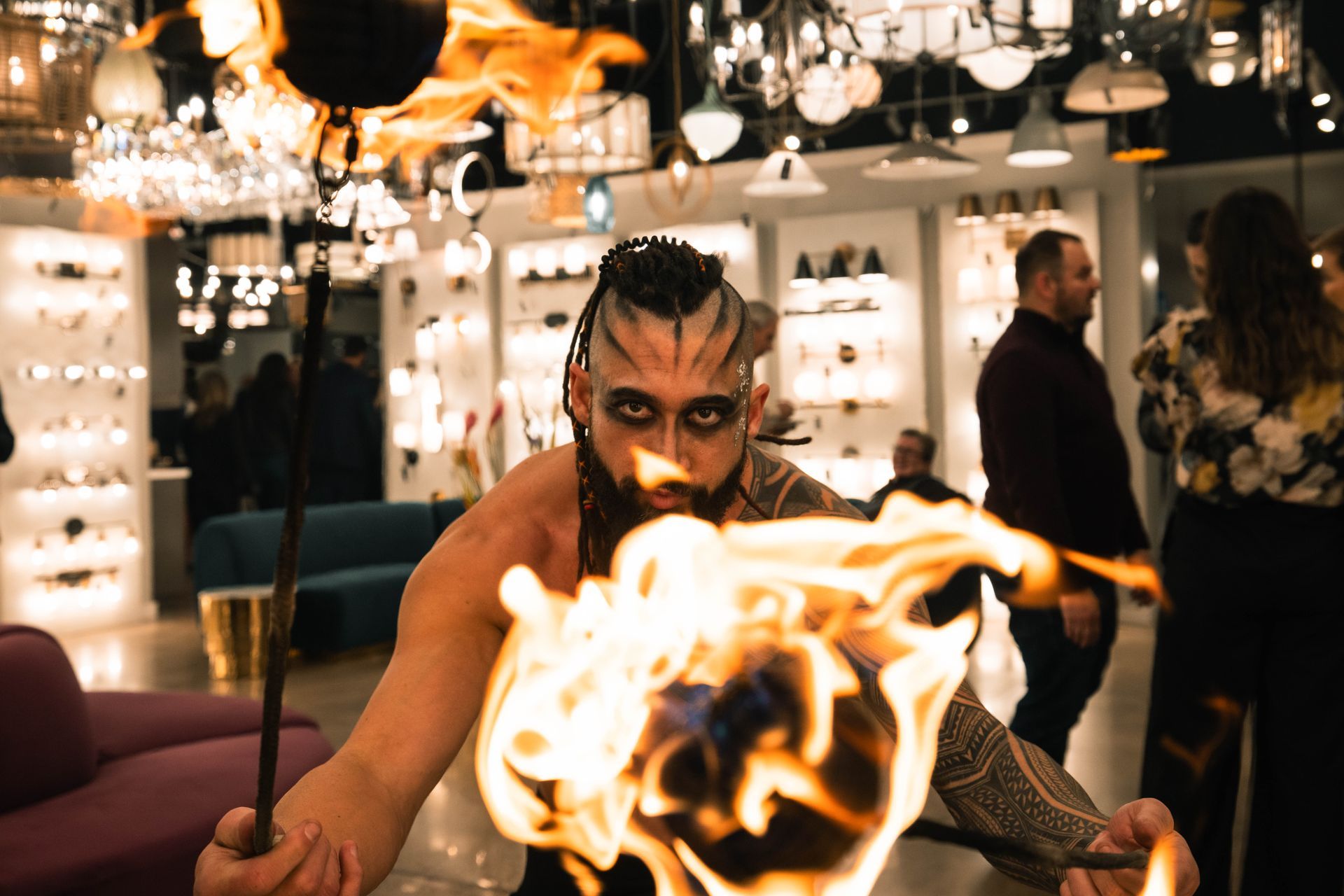 A man with a beard is holding a torch with flames coming out of it.