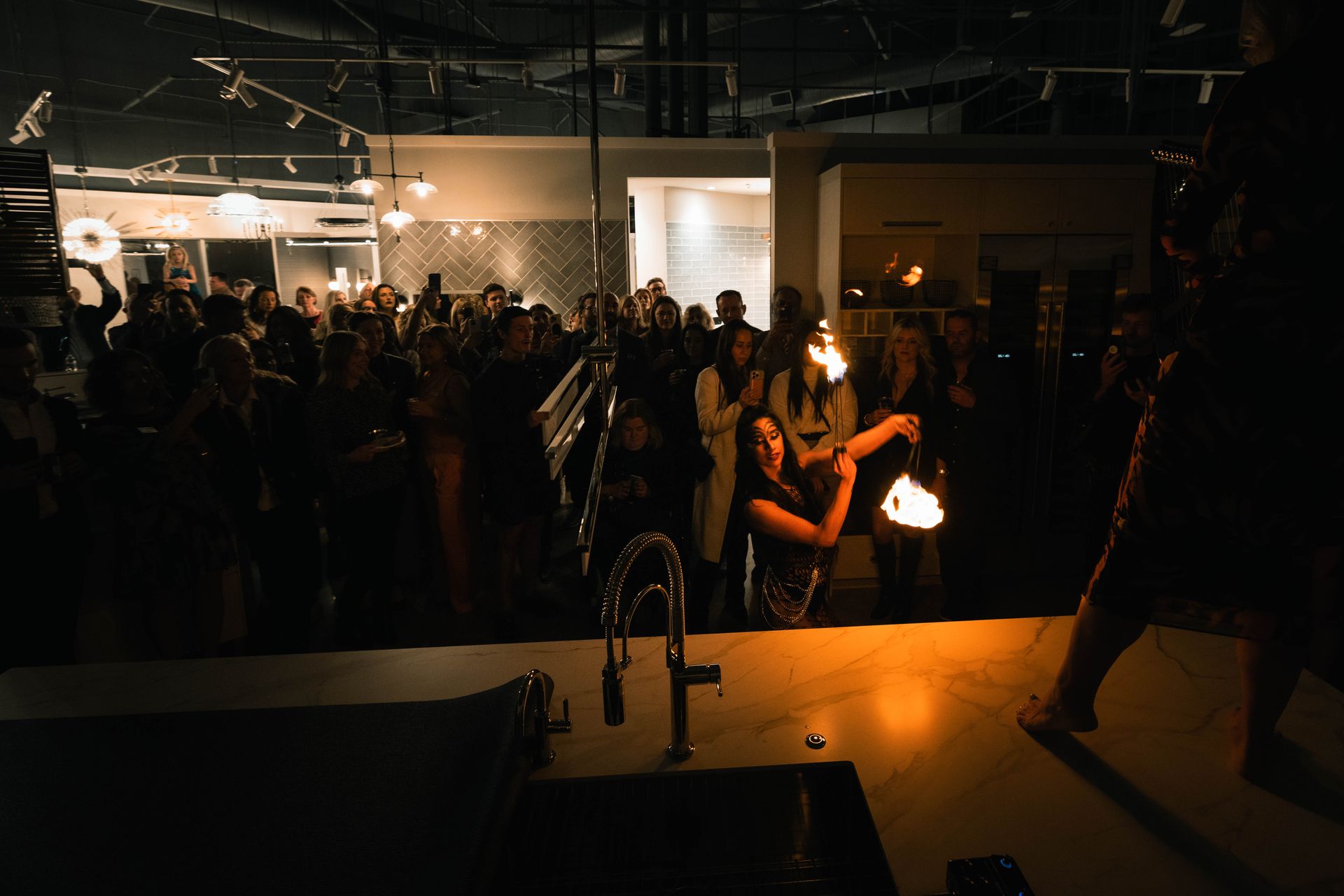A woman is holding a fireball in front of a crowd of people.