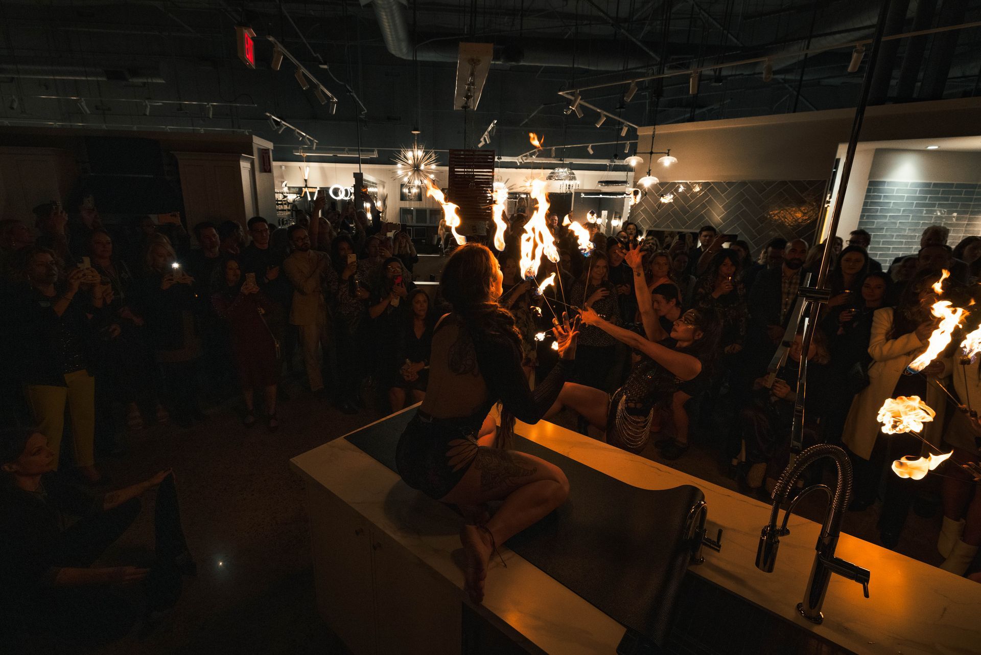 A woman is holding a torch in front of a crowd of people.