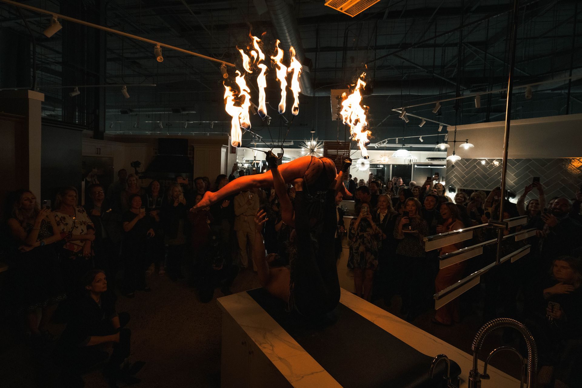 A woman is performing aerial acrobatics in front of a crowd of people.