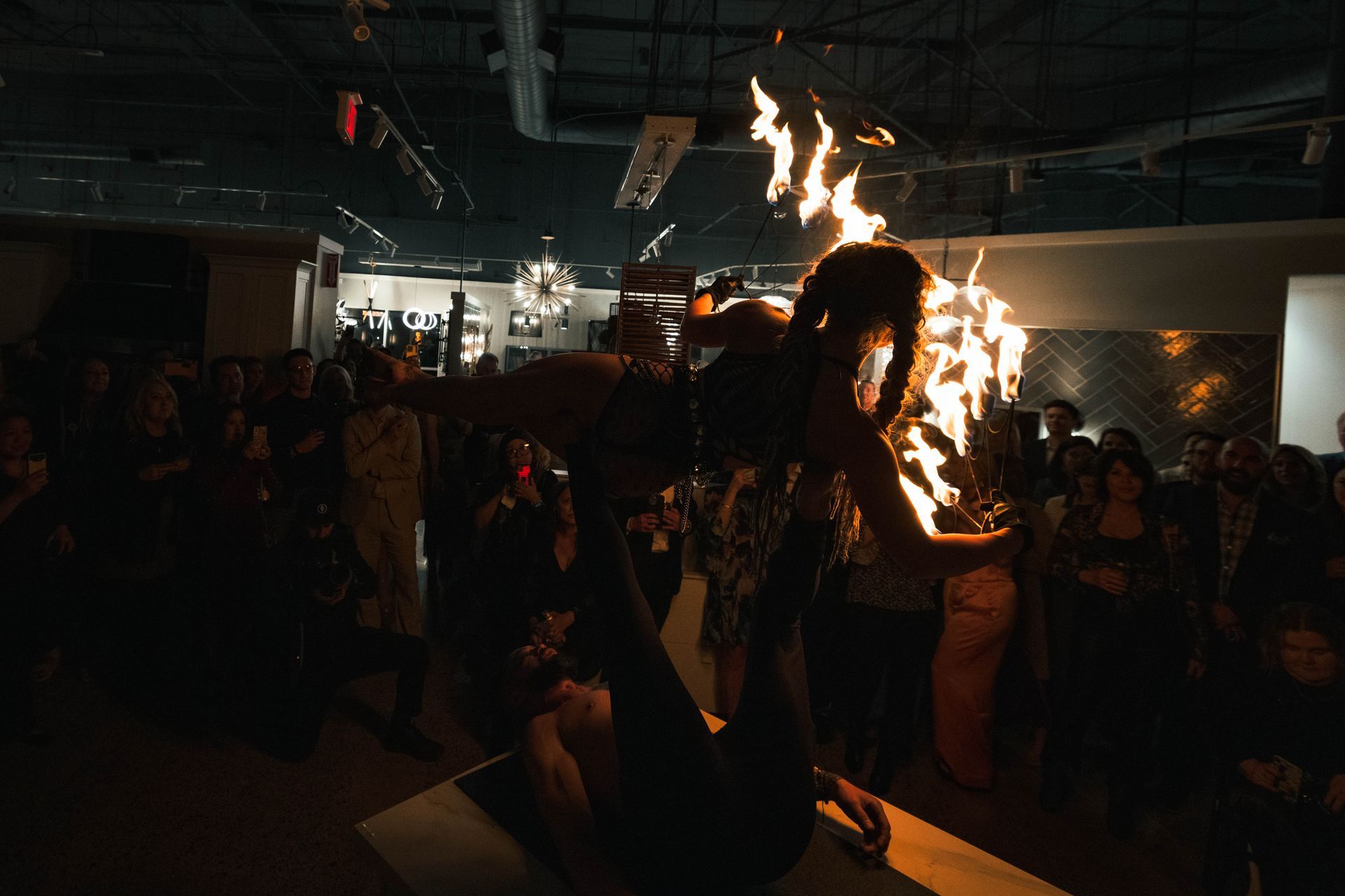 A woman is holding a torch in front of a crowd of people.