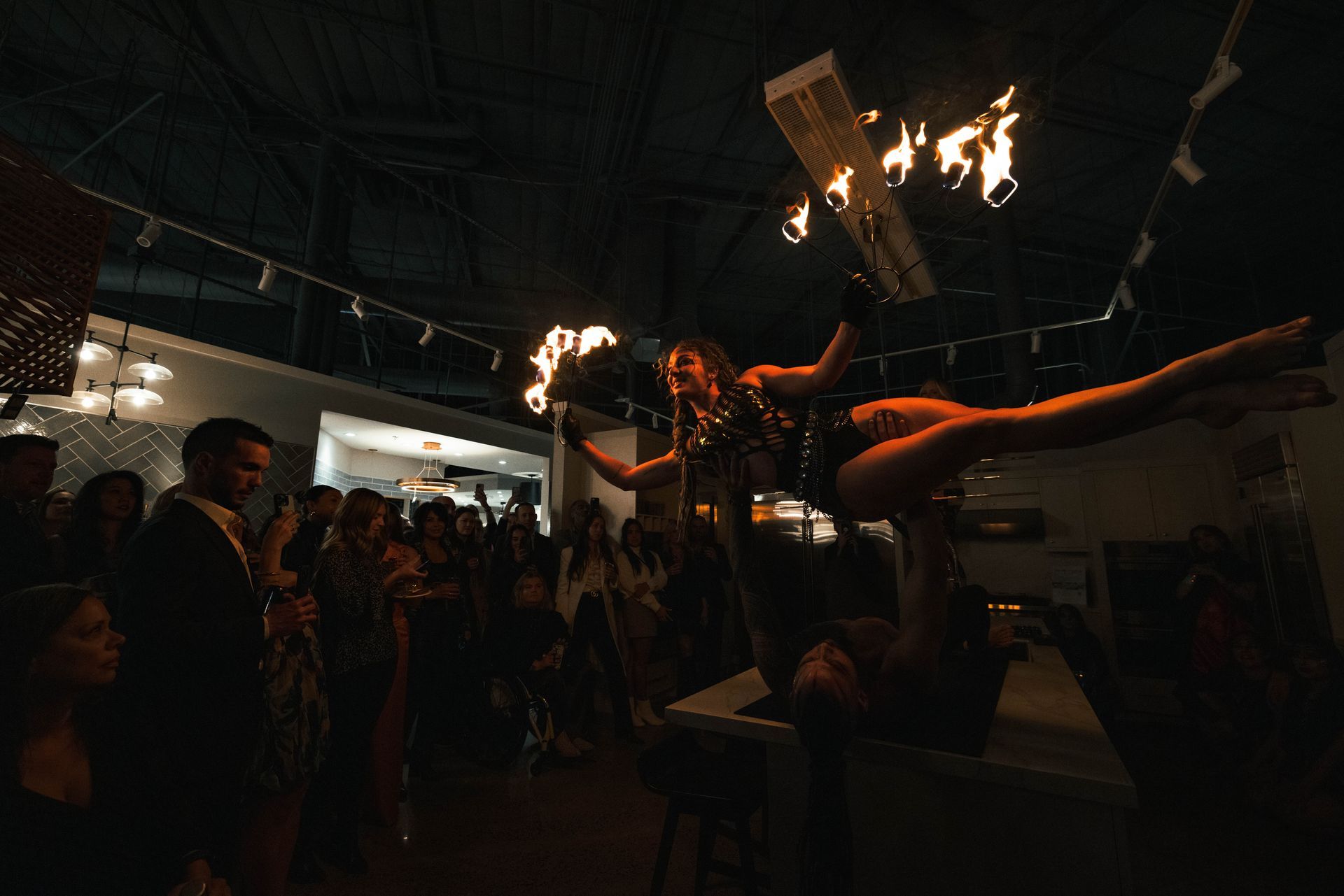 A woman is performing aerial acrobatics in front of a crowd of people.