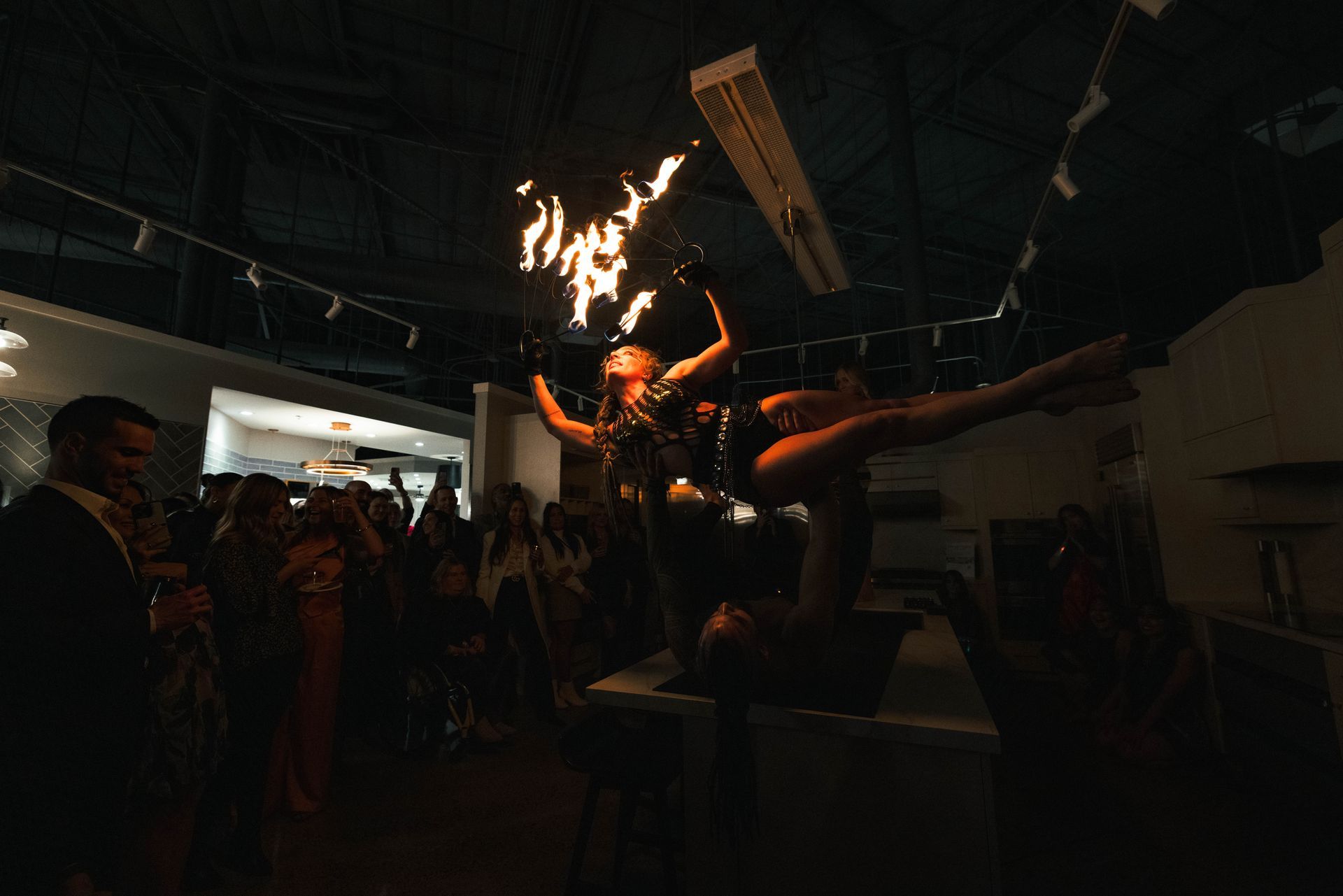 A woman is holding a torch in her hand in front of a crowd of people.
