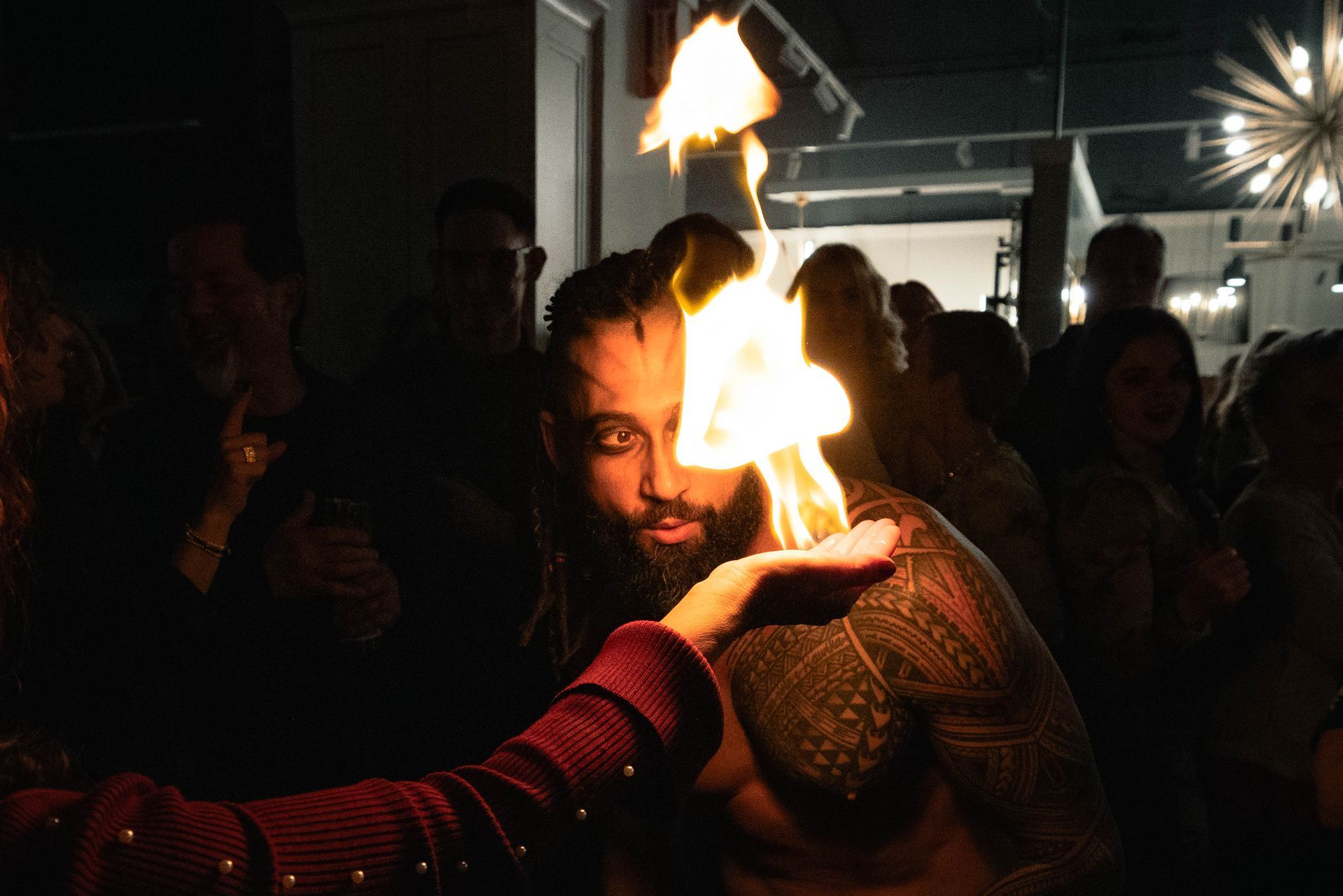 A man with a beard is holding a fire in his hand.