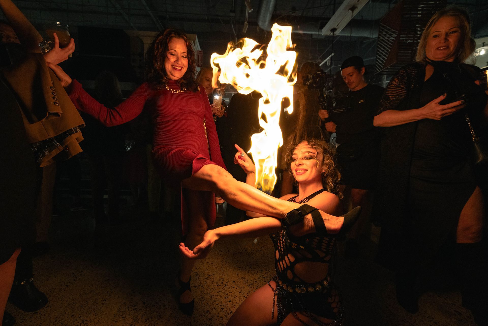 A woman is holding a torch with flames coming out of it.