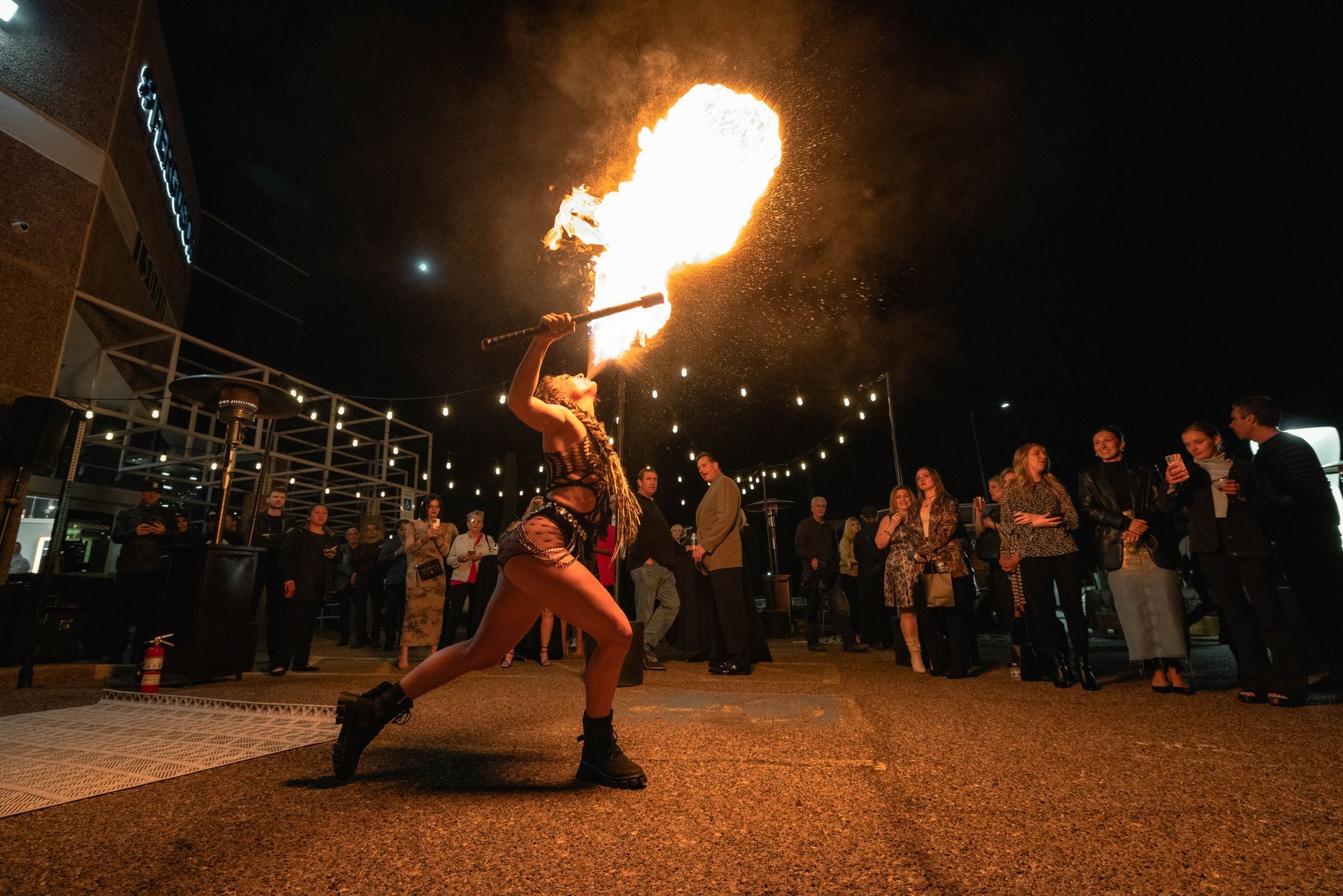 A woman is holding a torch with flames coming out of it.