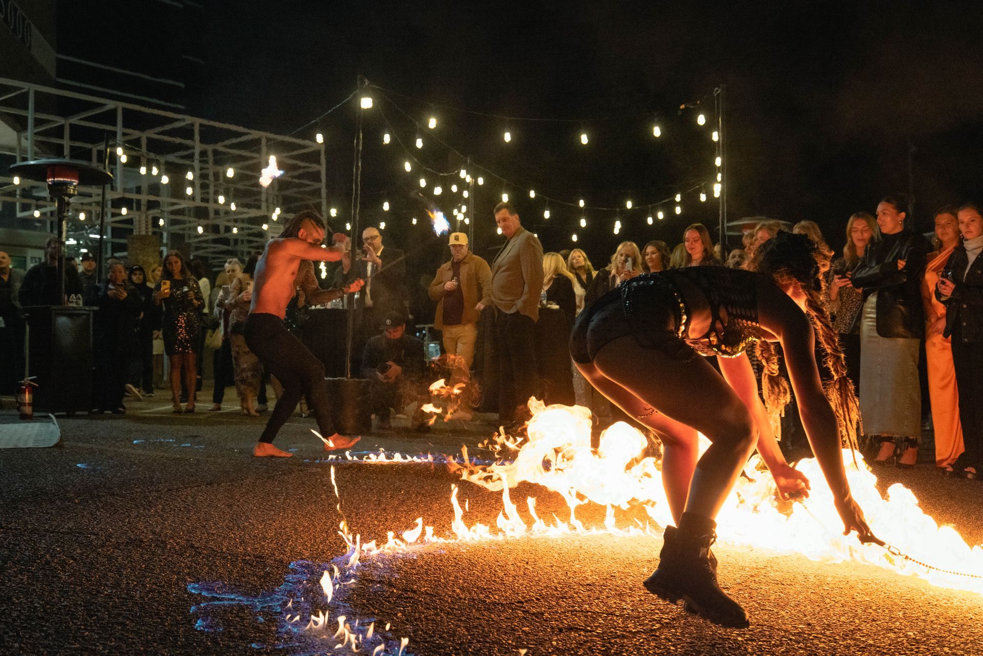 A group of people are standing around a fire.