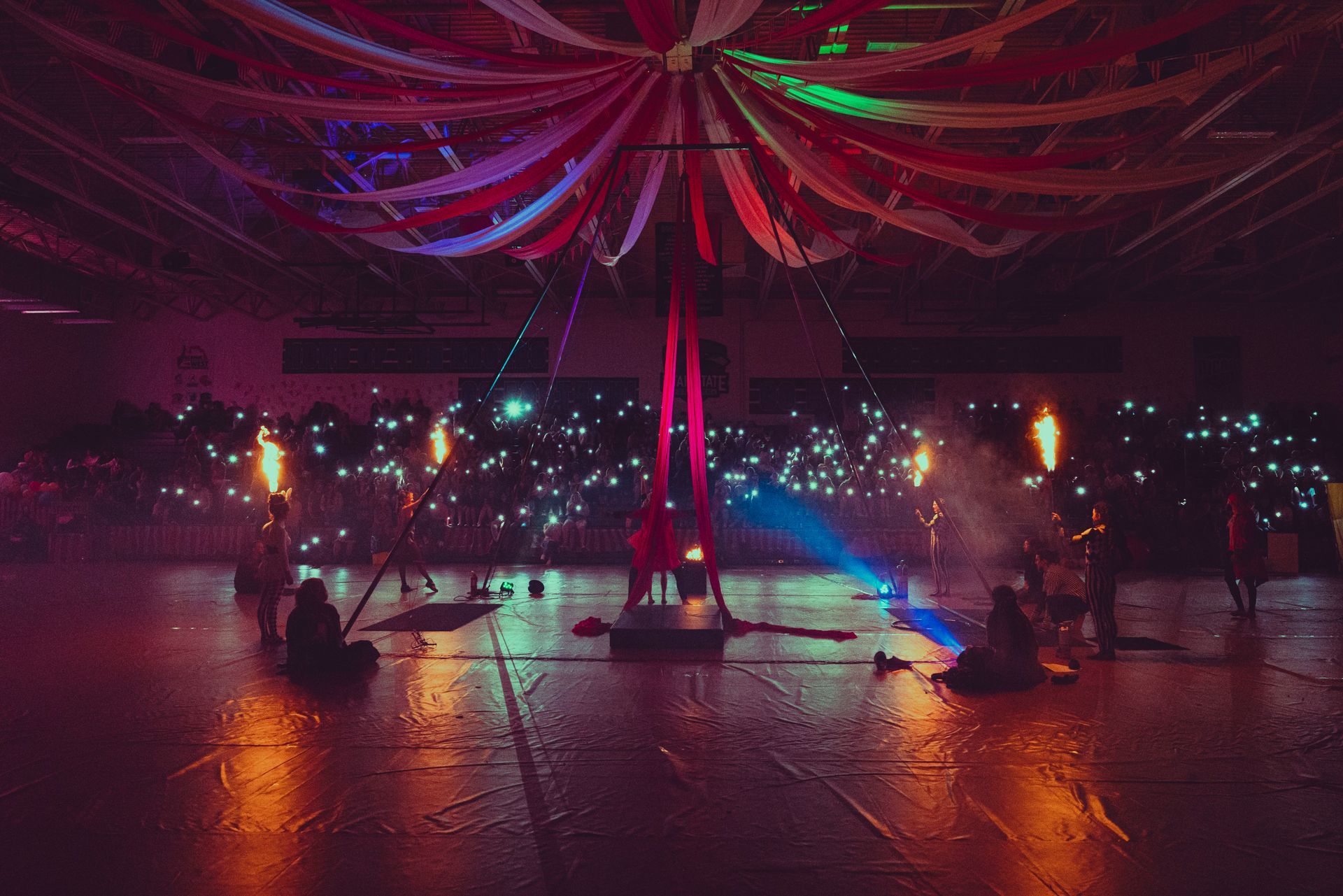 A group of people are standing on a stage in a dark room.