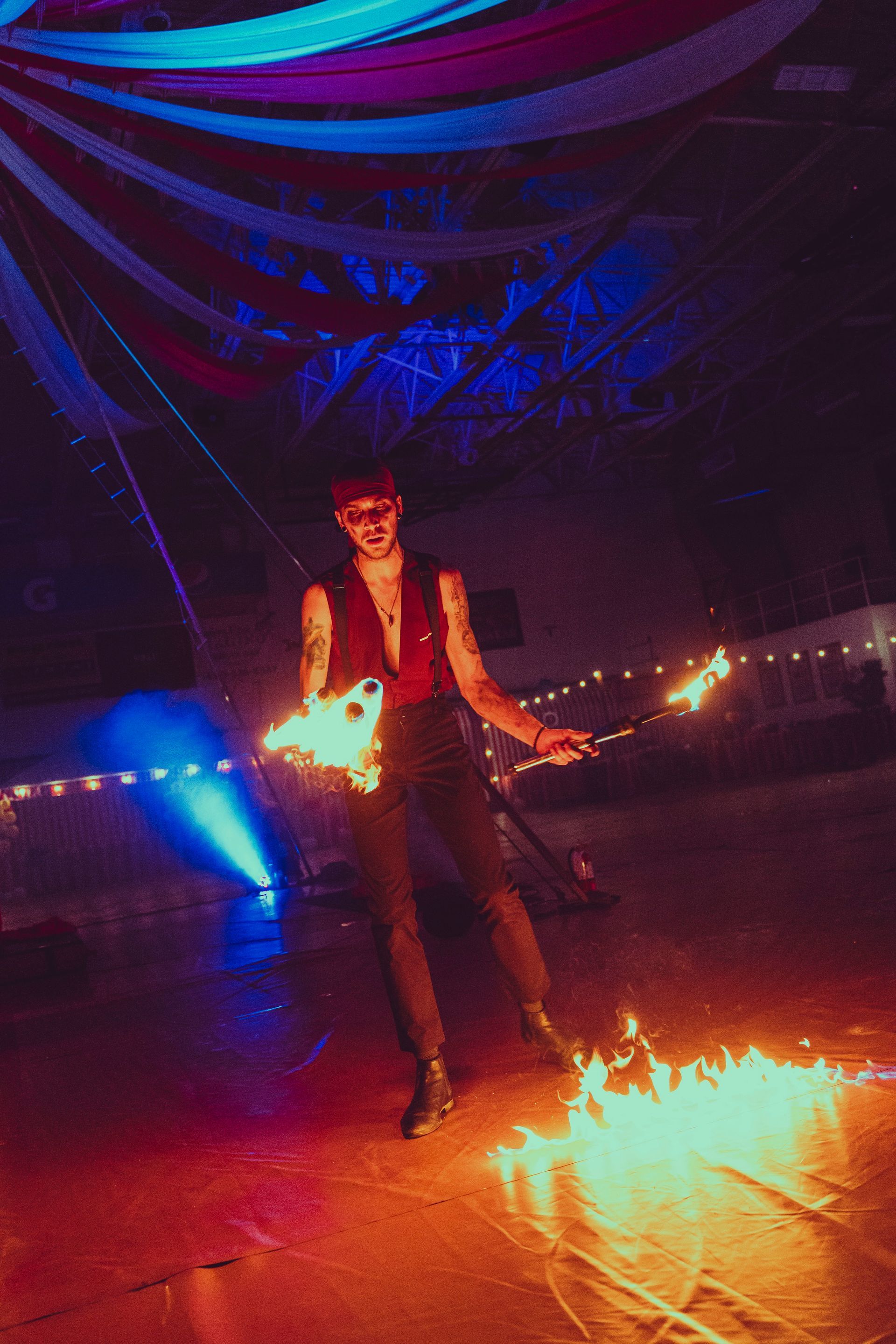 A man is standing on a stage holding a fire torch.