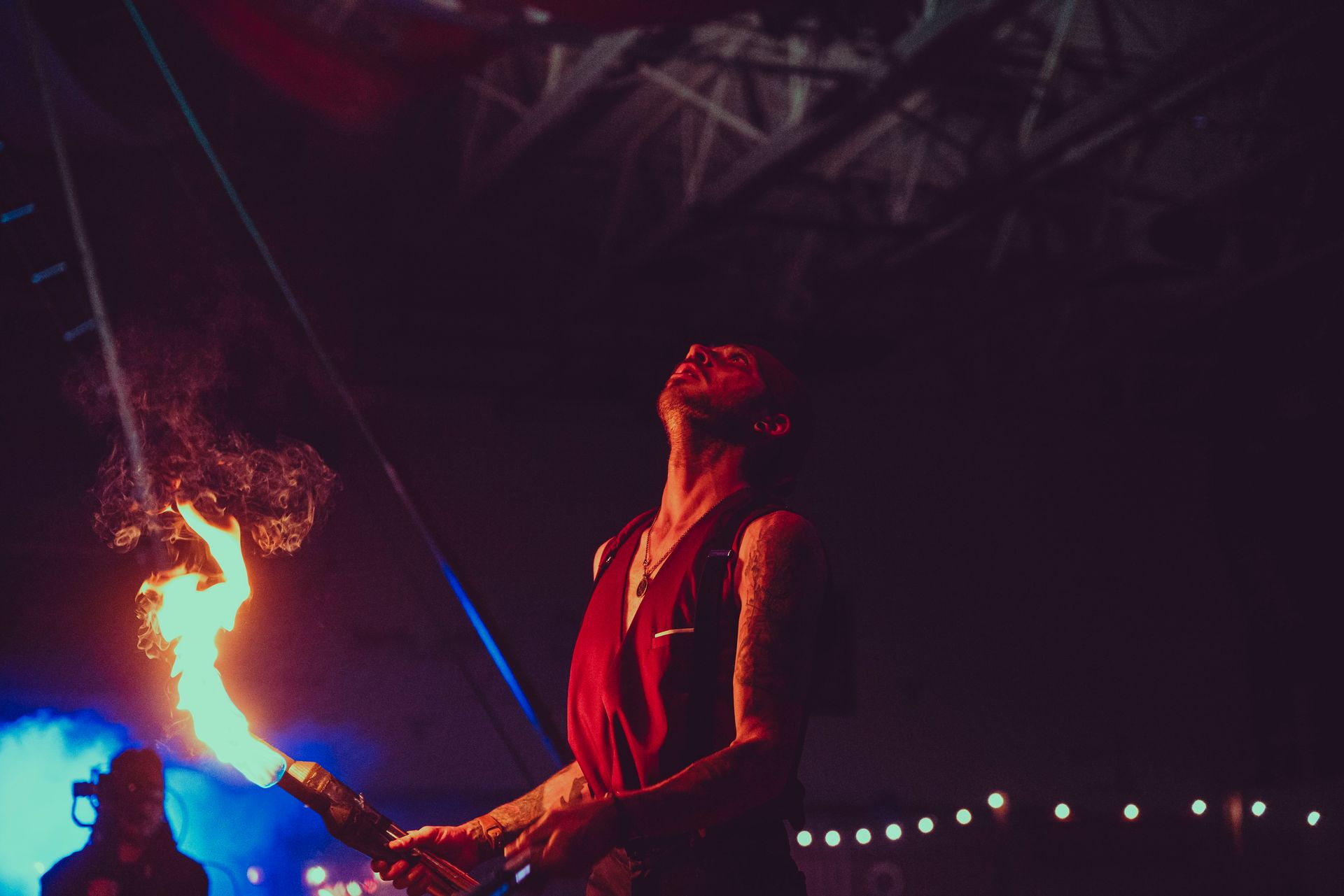 A man is holding a torch with flames coming out of it.