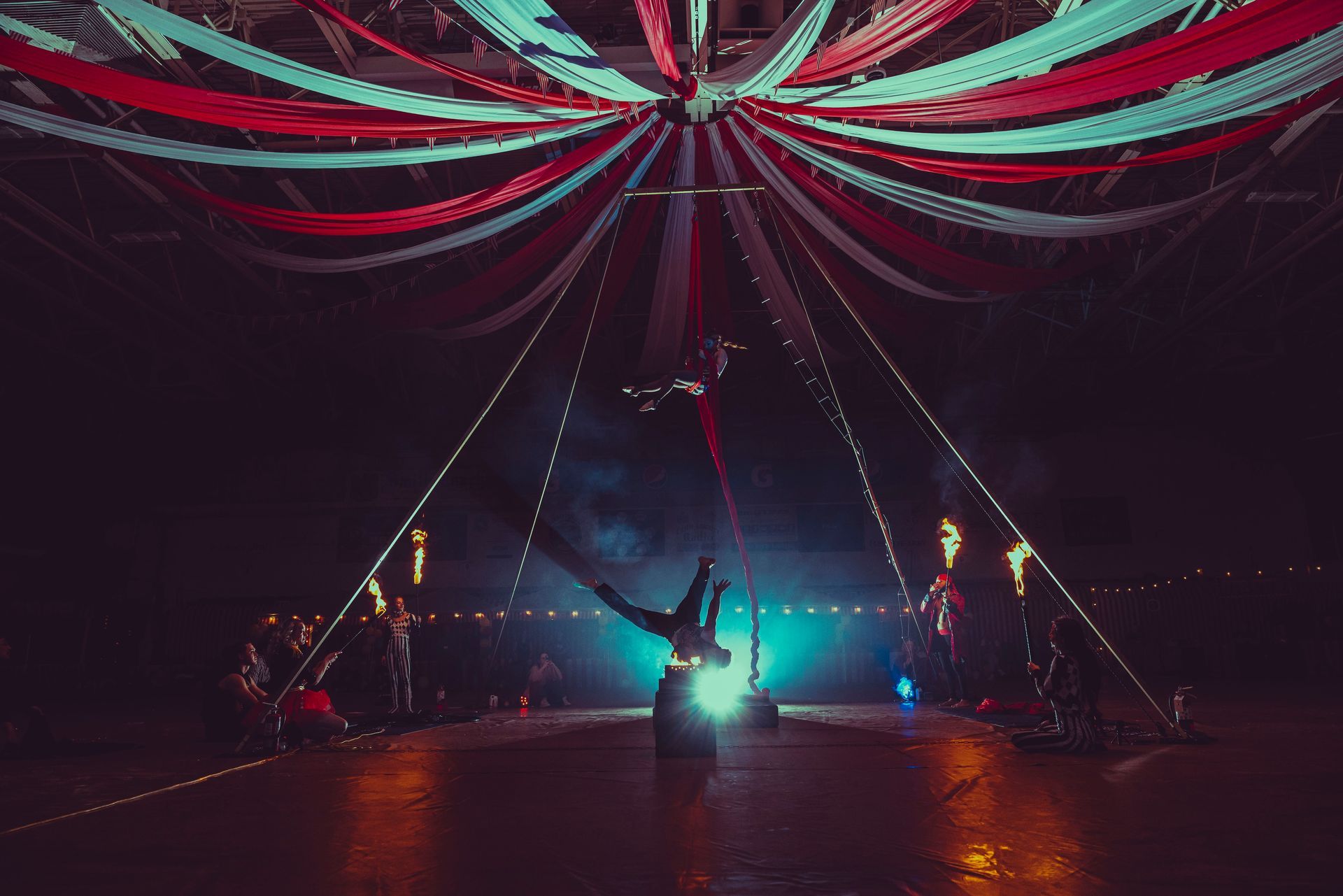 A person is performing aerial acrobatics in a dark room.