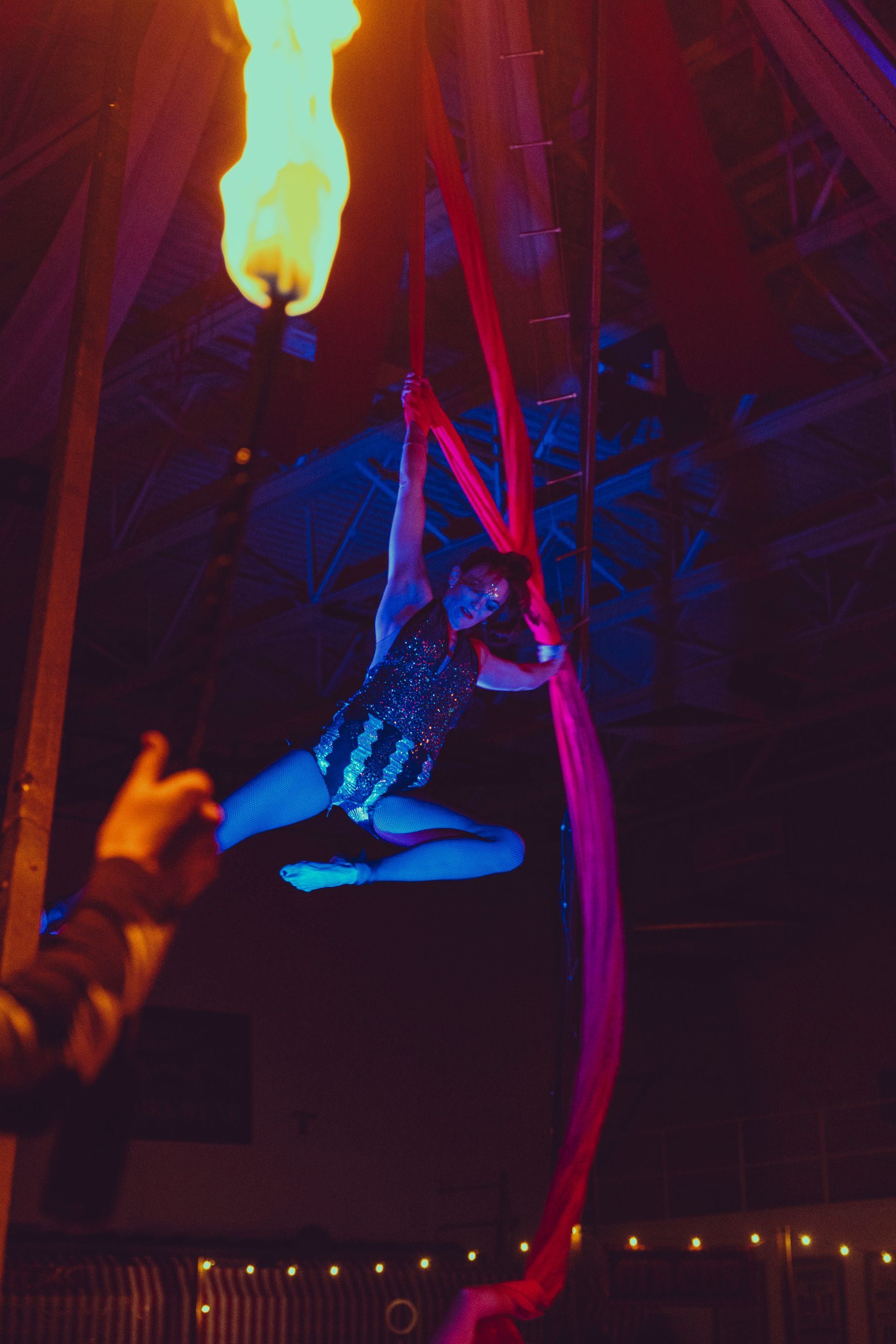 A woman is flying through the air while holding a torch.