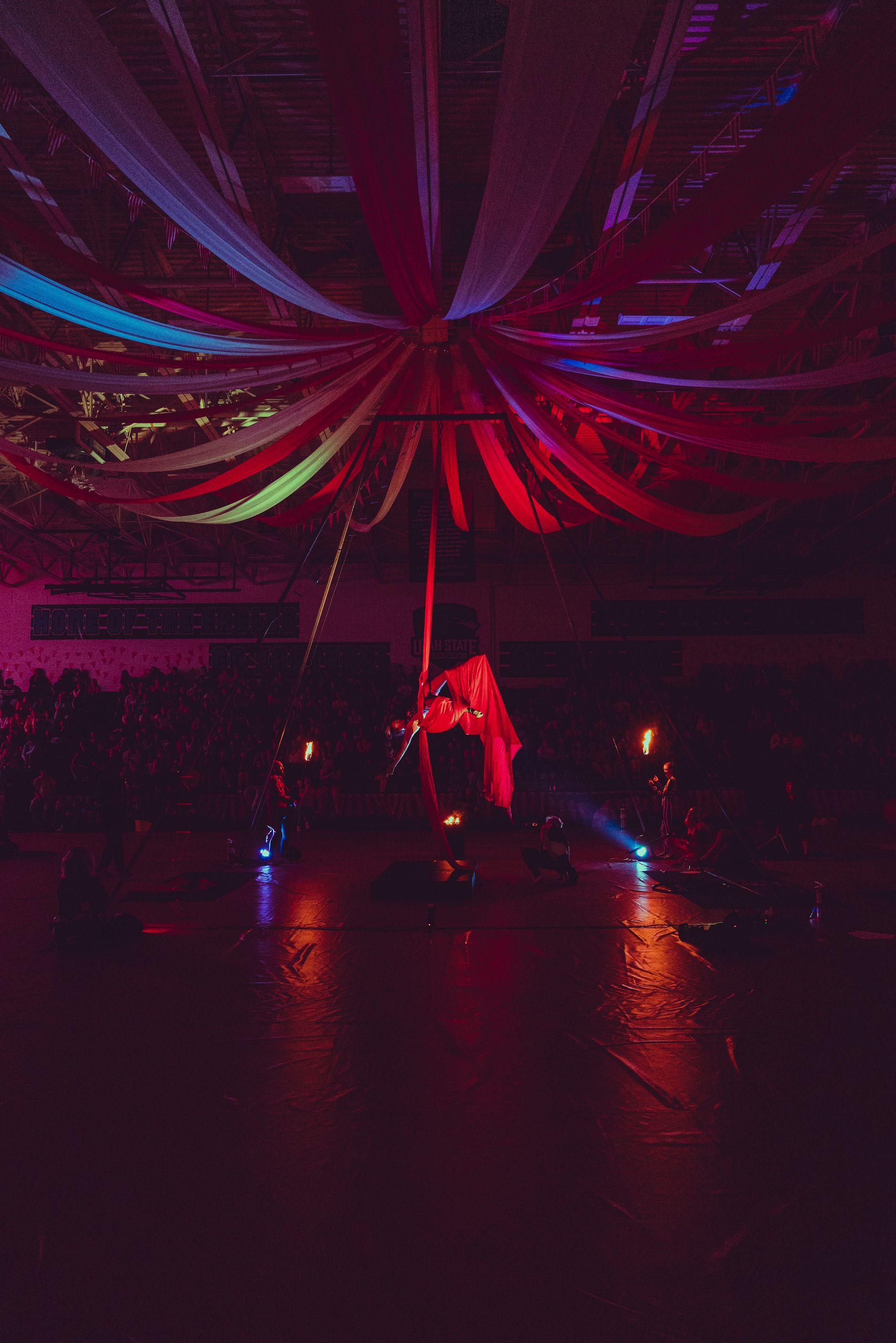A woman is dancing on a pole in a dark room.
