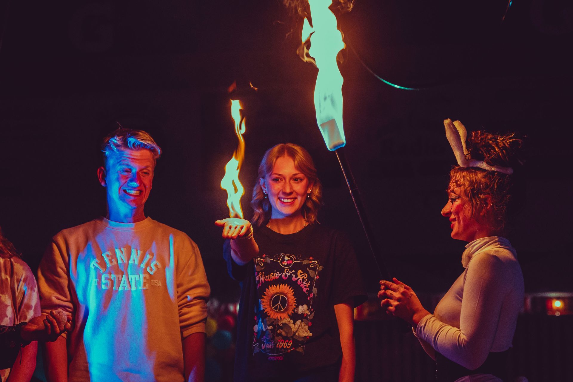 A group of people are standing around a fire torch.