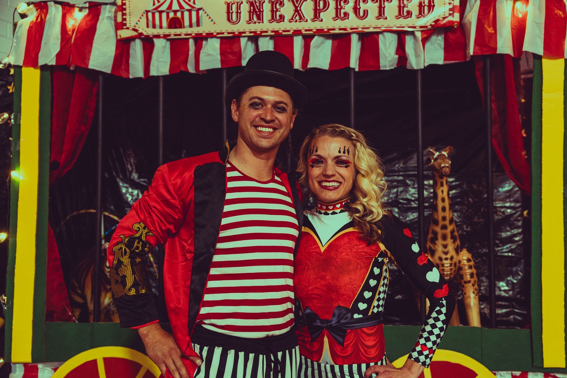 A man and a woman in circus costumes are posing for a picture.