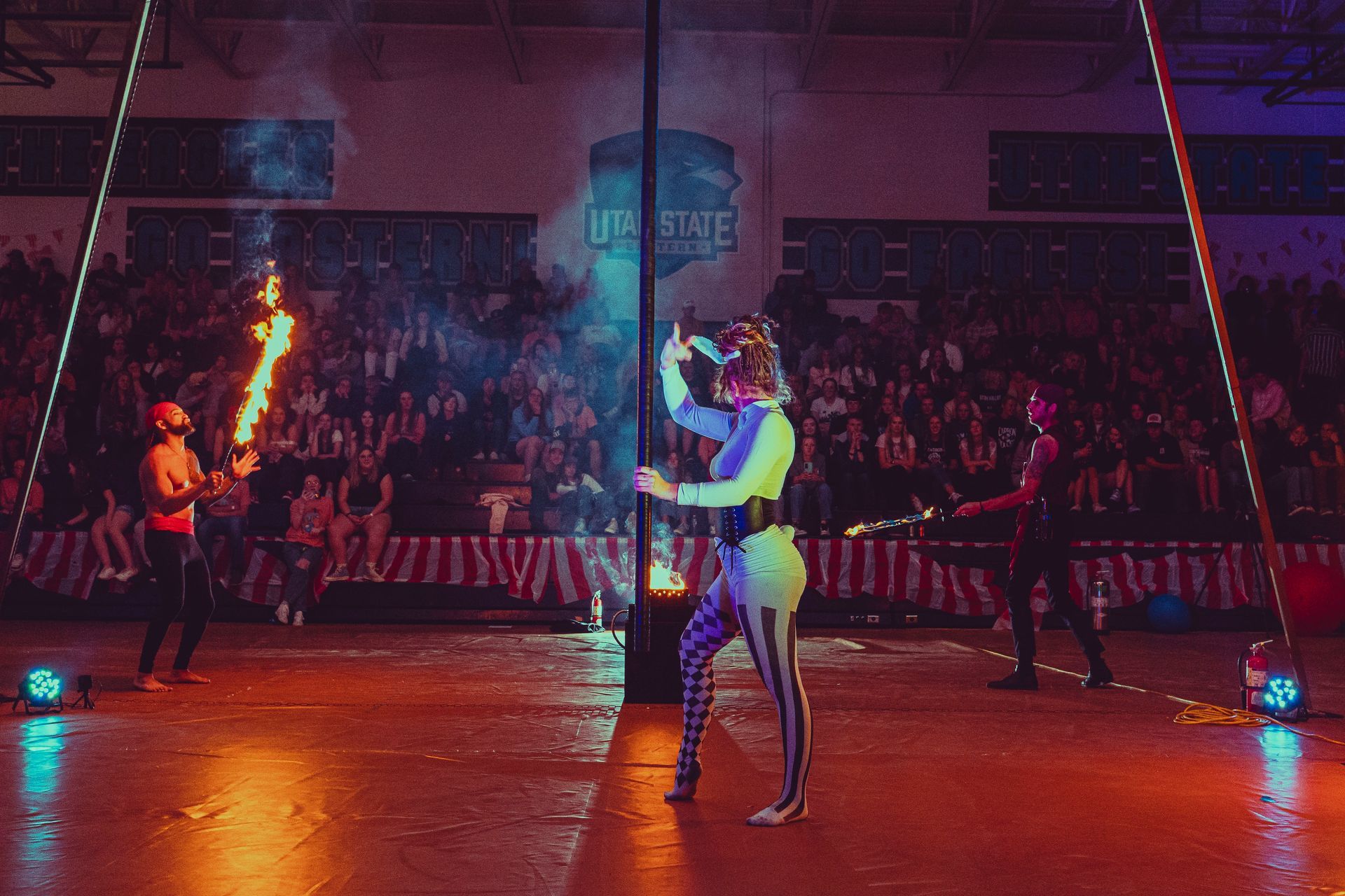 A group of people are performing a circus show in front of a crowd.