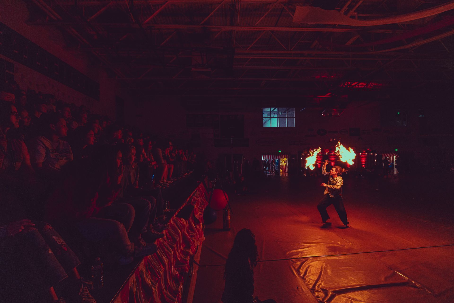 A man is standing on a stage in front of a crowd in a dark room.