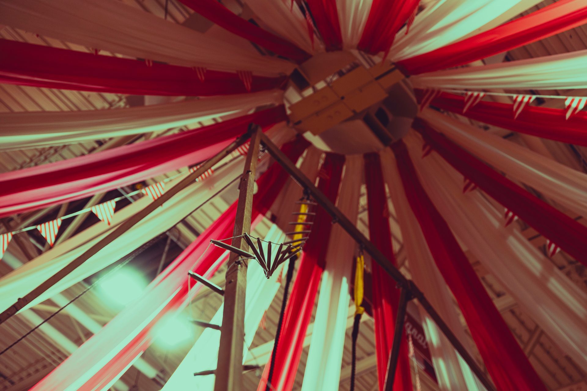 Looking up at the ceiling of a ferris wheel covered in red and white fabric.