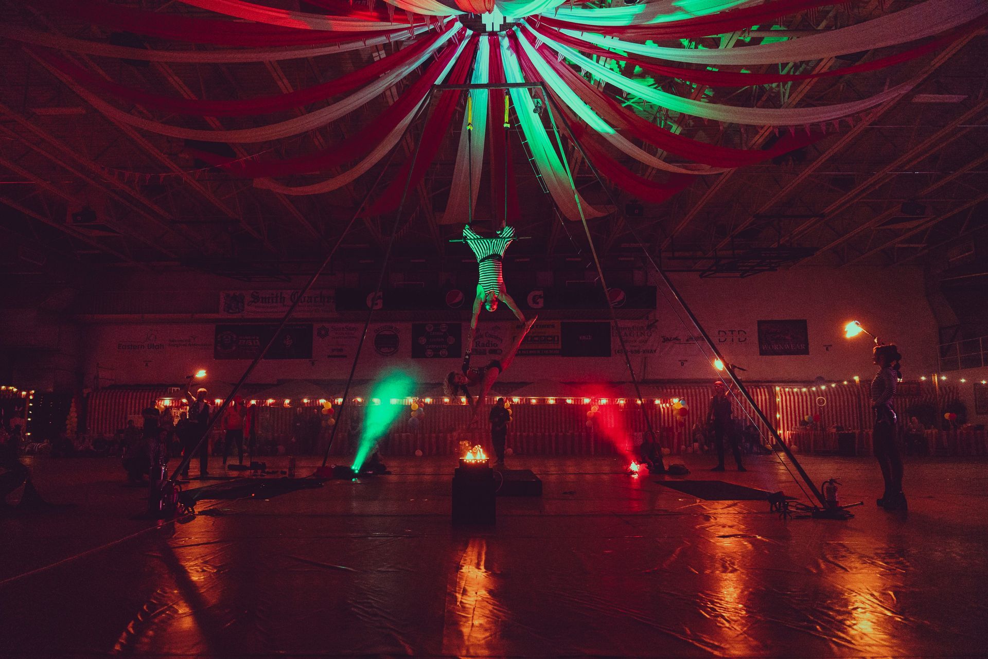 A person is performing aerial acrobatics in a dark room.