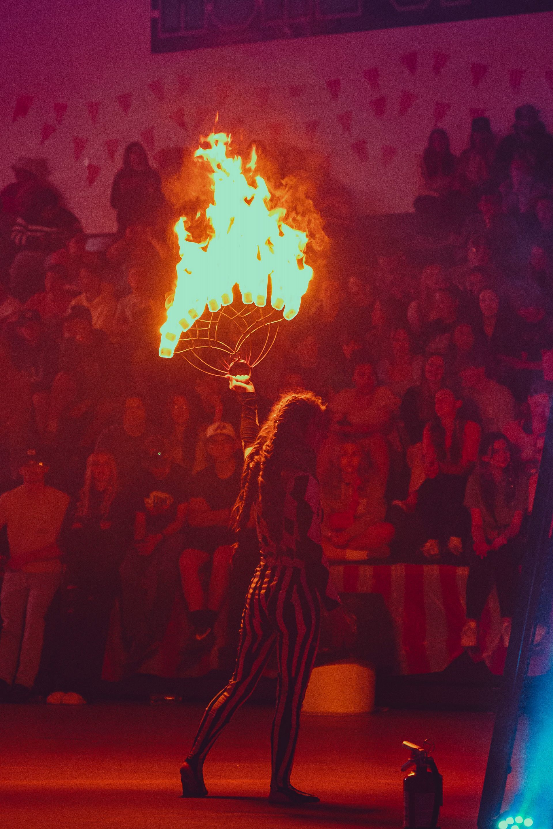 A woman is holding a torch in front of a crowd of people.