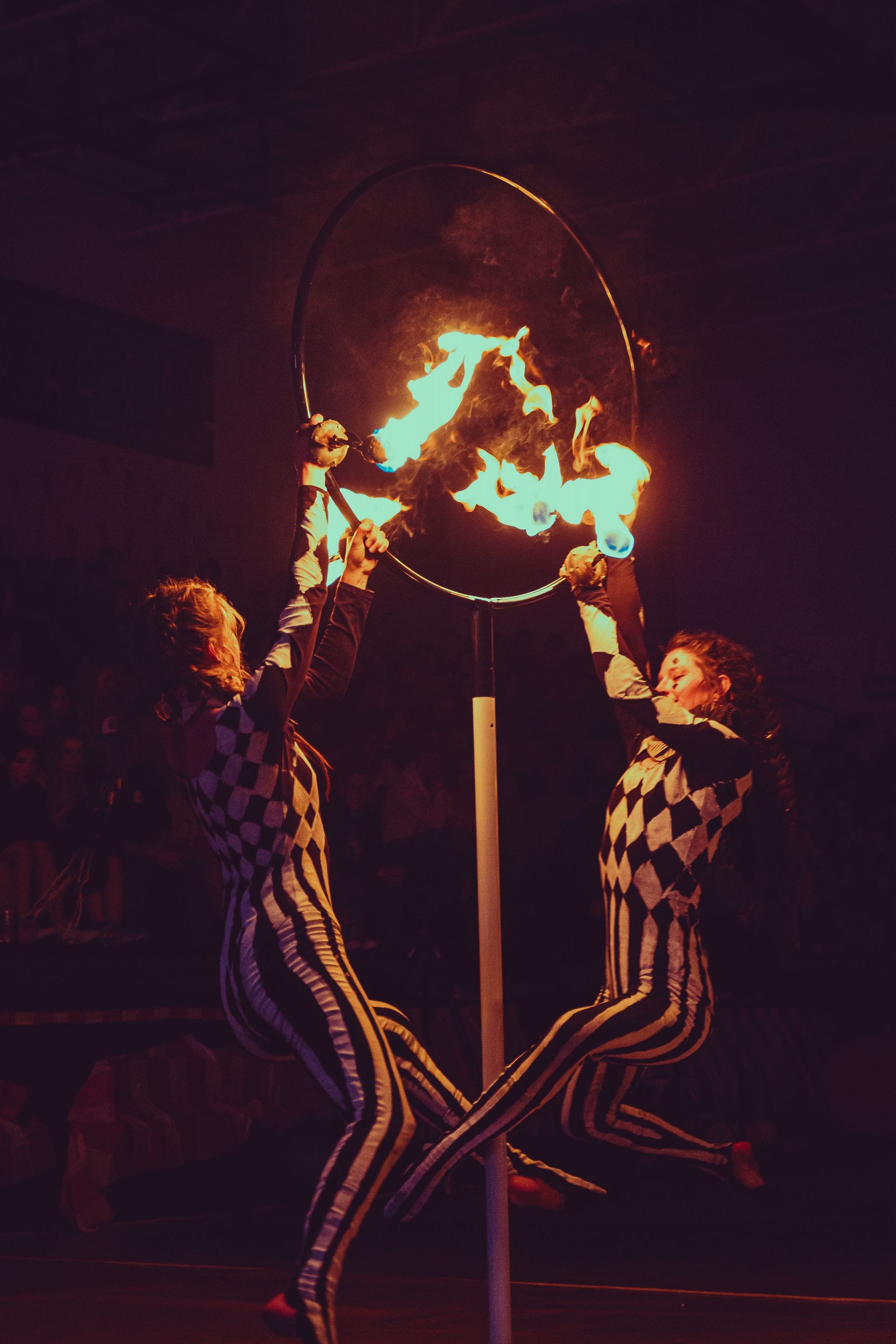 A group of people are holding a hoop with fire in it