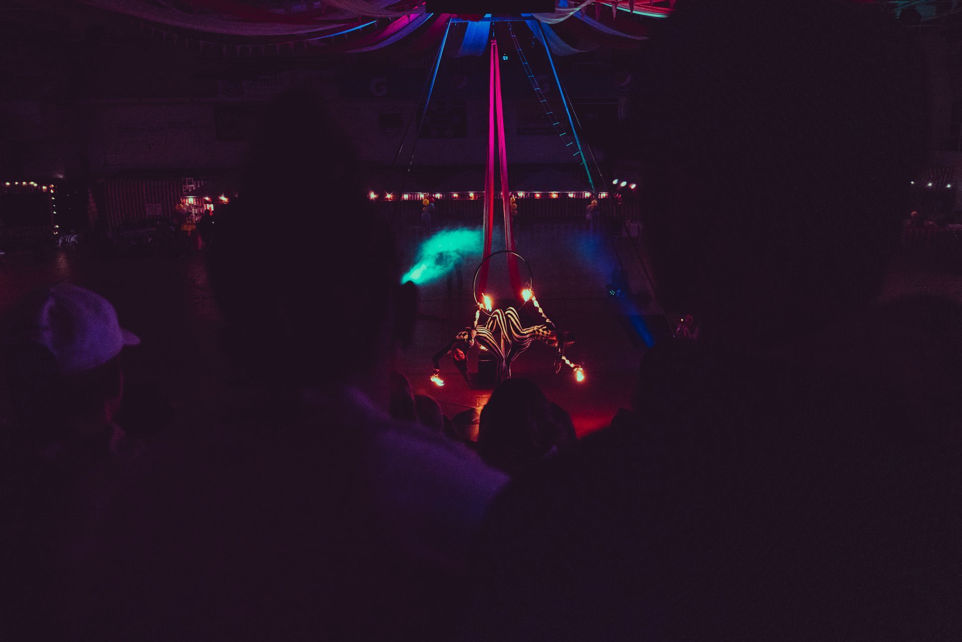 A group of people are dancing in a dark room at a party.