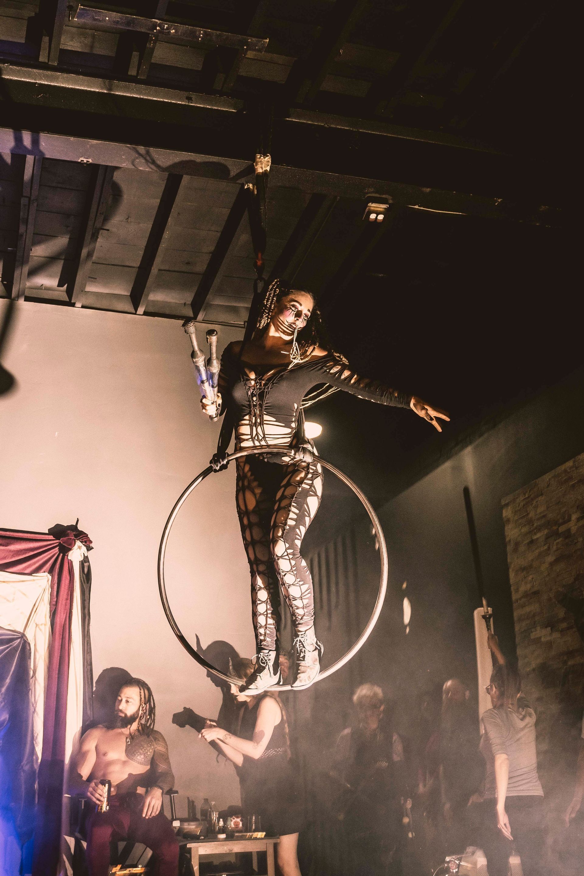 A woman is hanging from a hoop in the air.