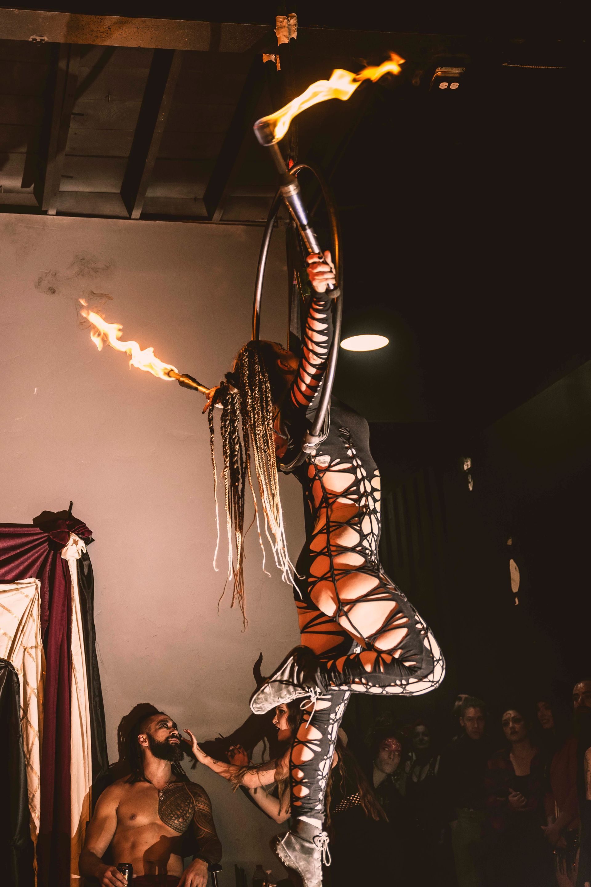 A woman is flying through the air while holding a fire torch.