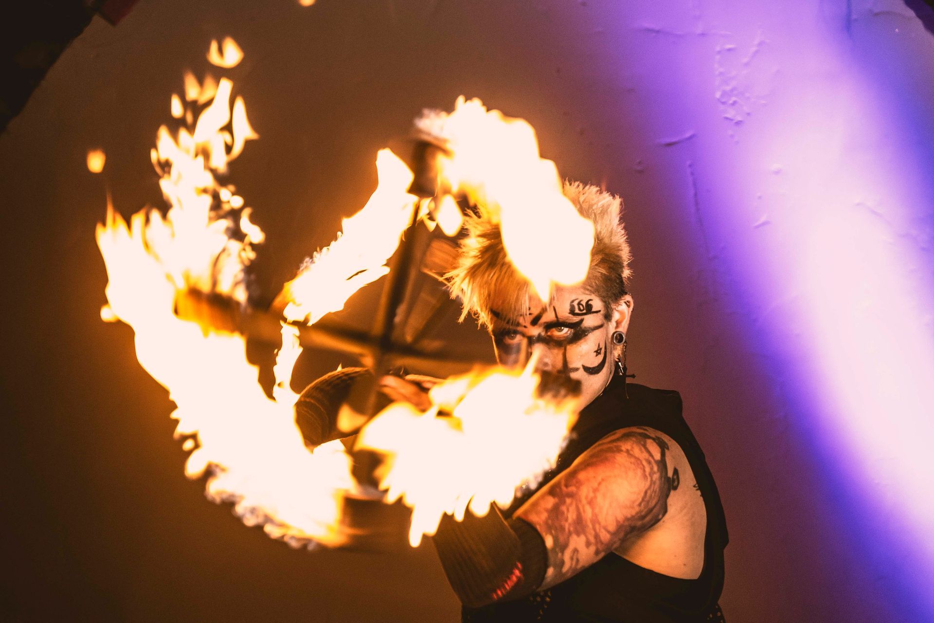 A woman performing with a Dragon Staff looking through the flames.