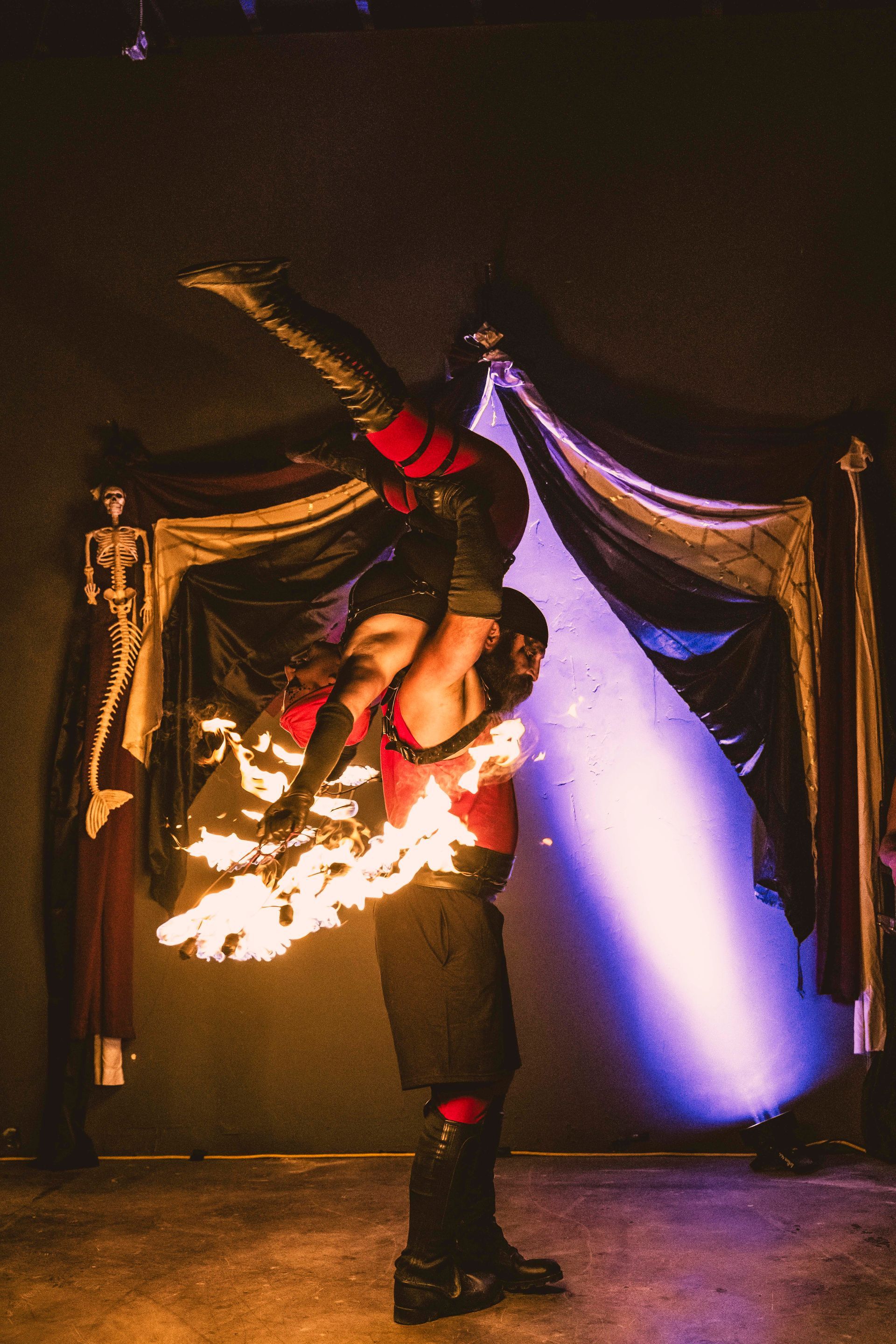 A man and woman performing acrobatic fire in a show.