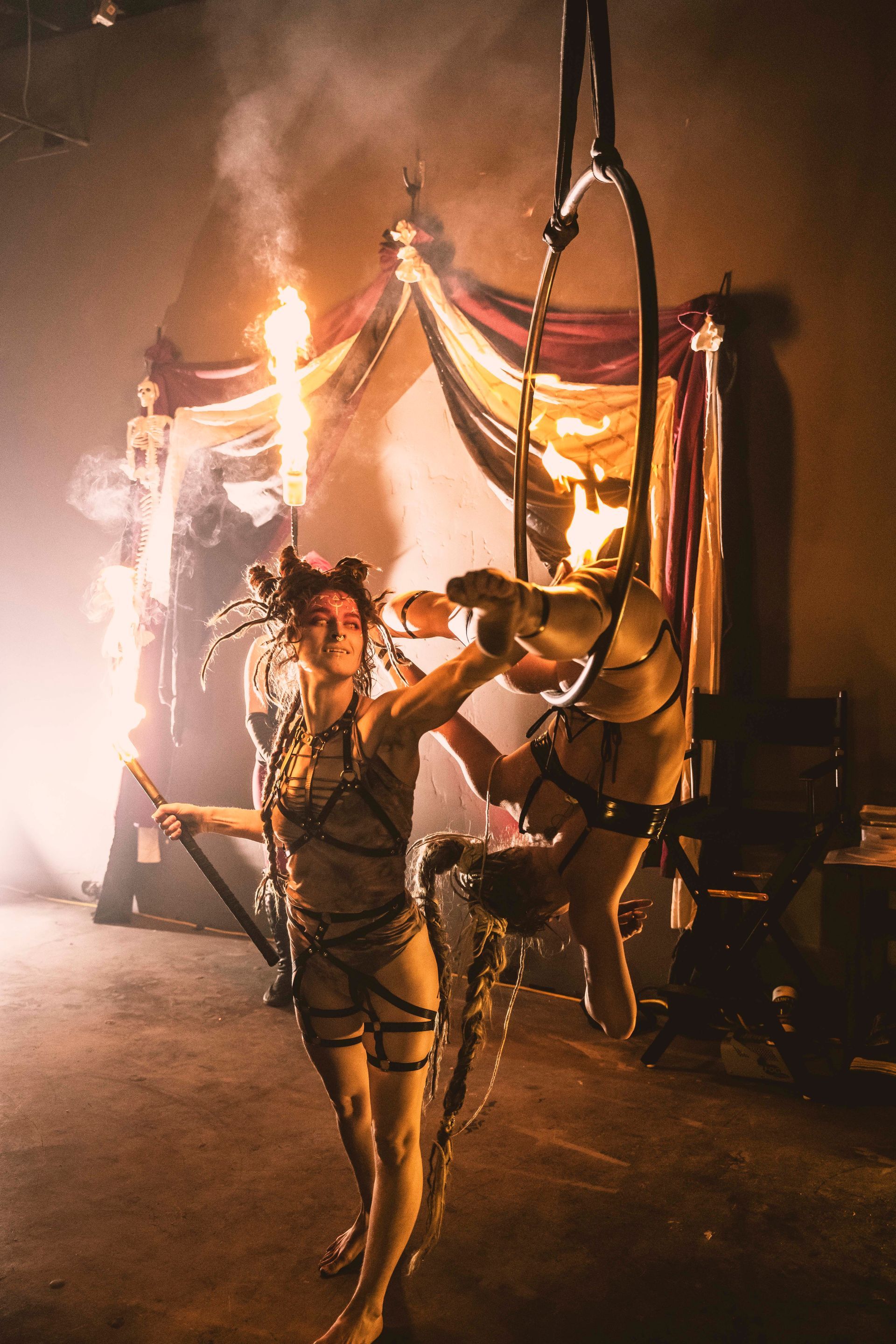 A woman is performing aerial acrobatics with a horse.