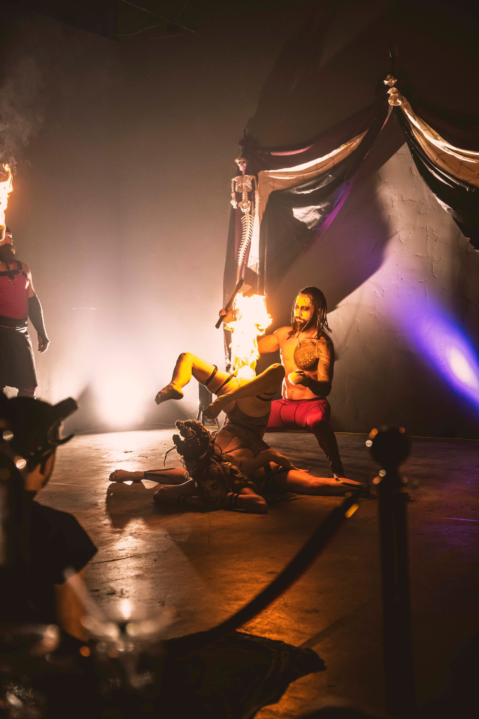 A group of people are performing on a stage in a dark room.