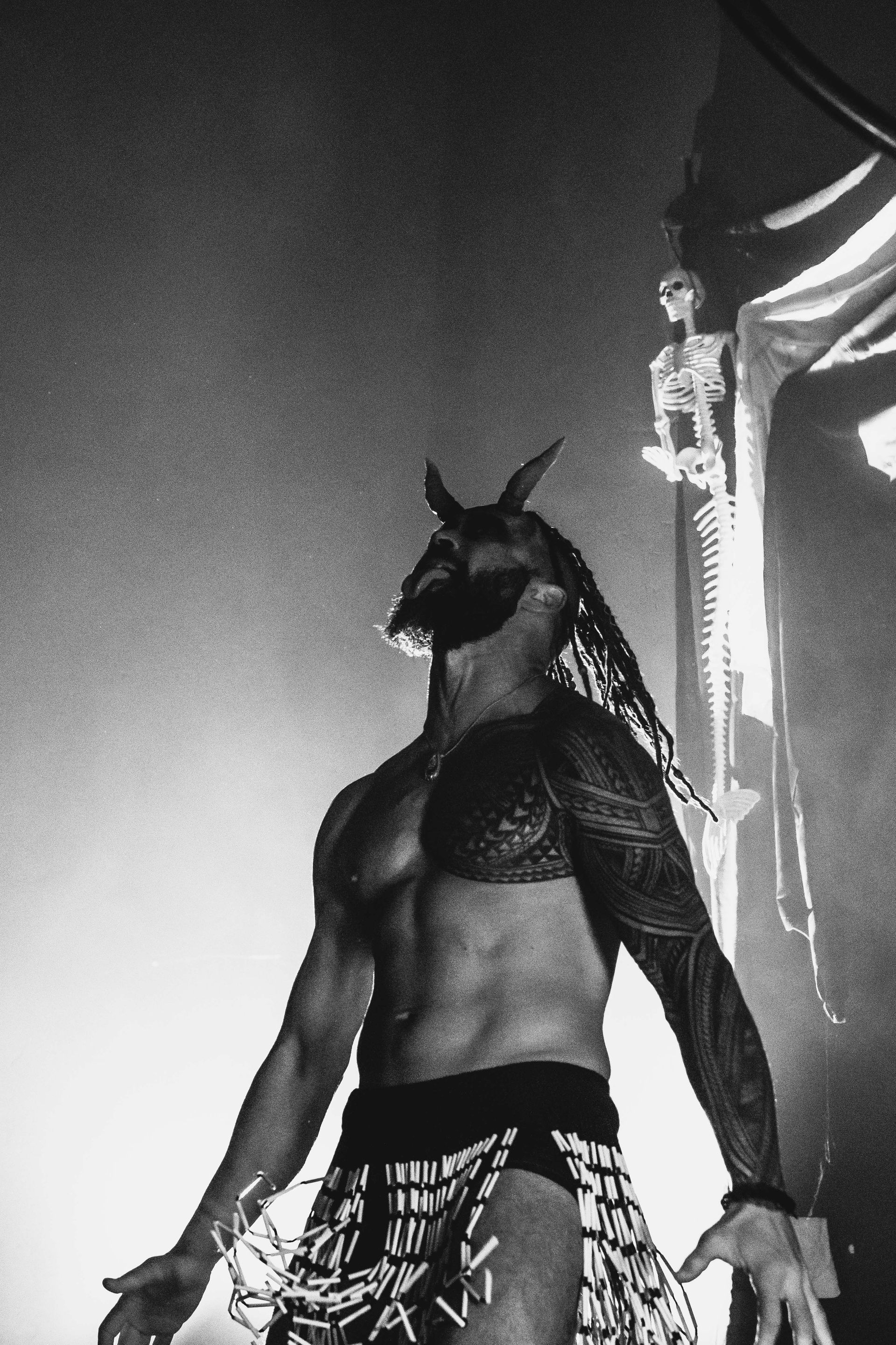 A black and white photo of a man in a costume with horns