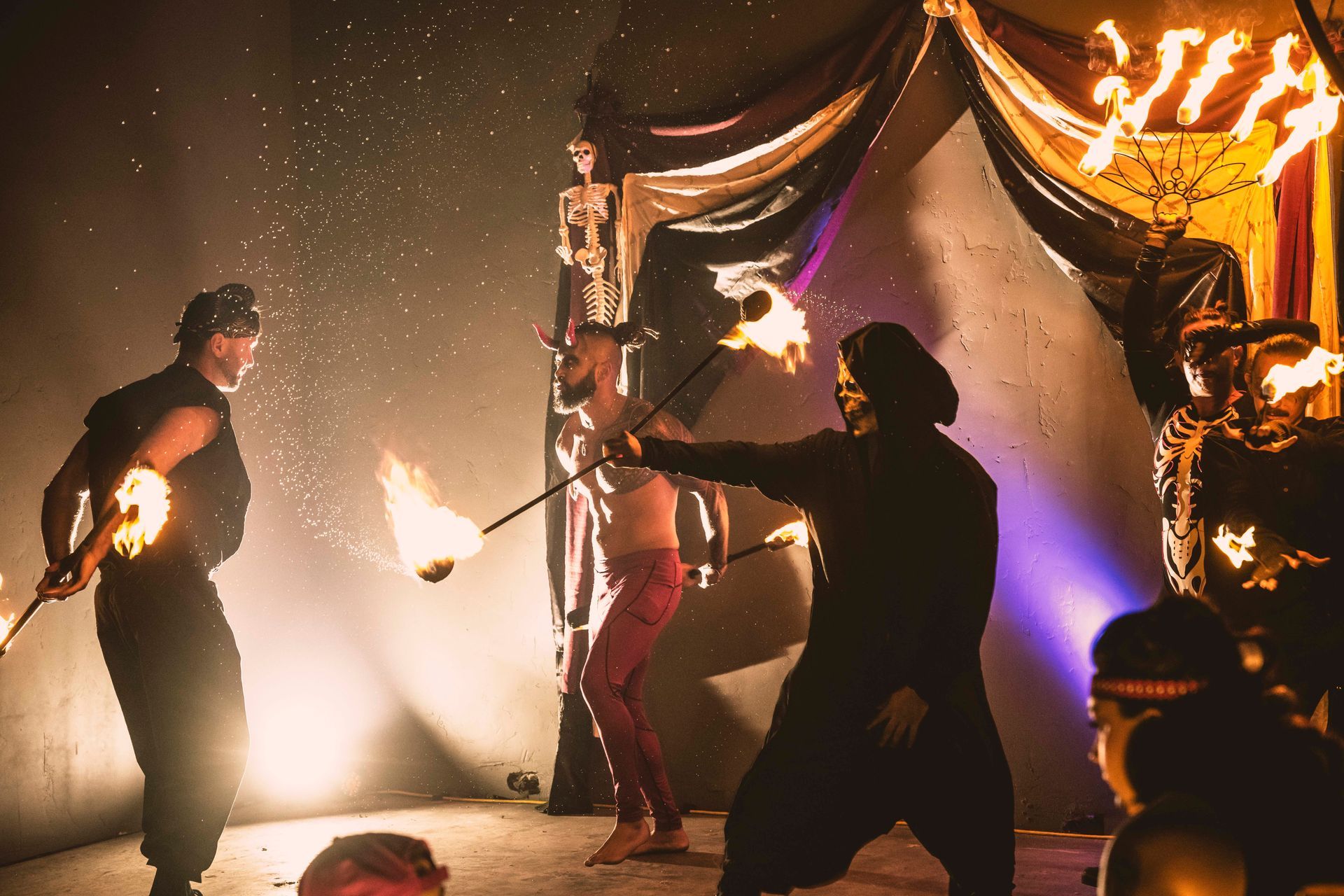 A group of people are performing a fire show on a stage.