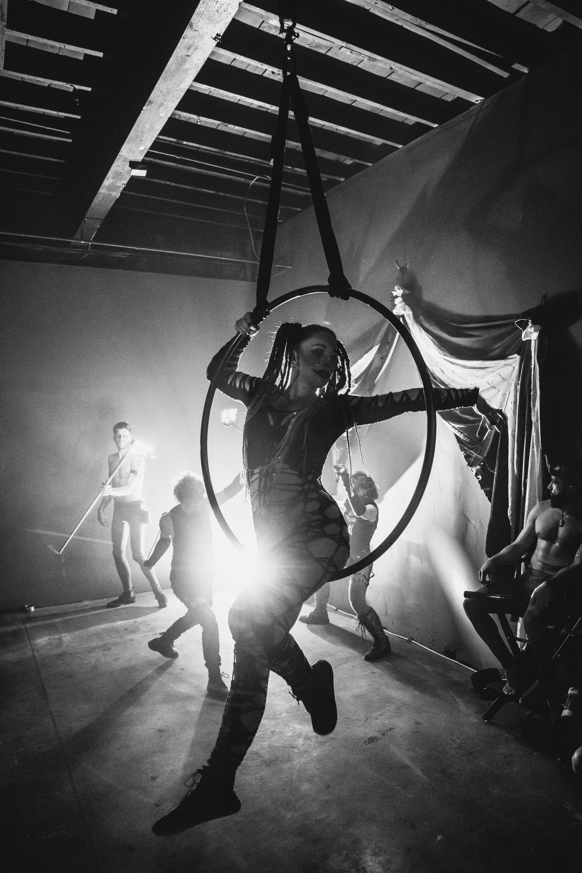 A black and white photo of a woman in an aerial hoop