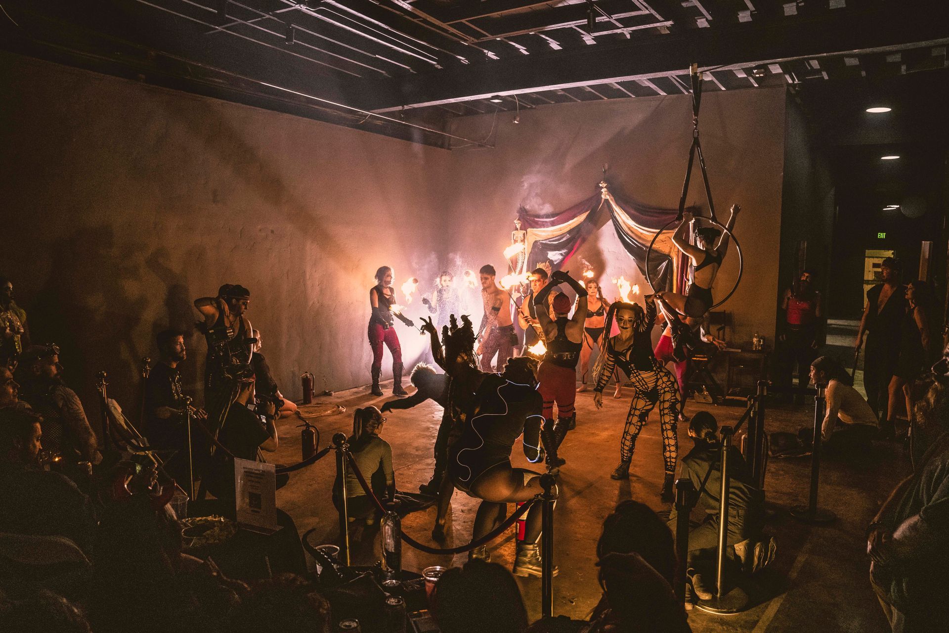 A group of people are dancing on a stage in a dark room.