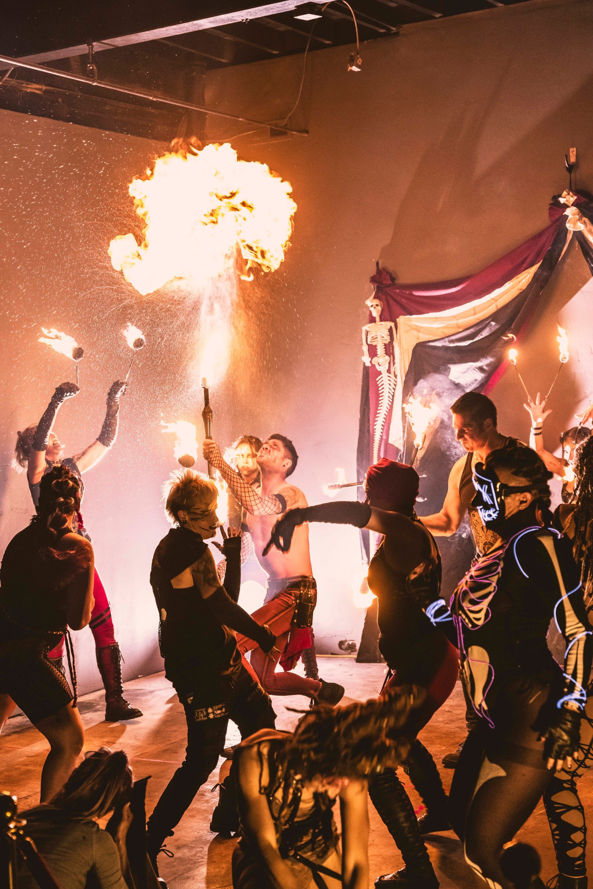 A group of people are dancing in a room with fire coming out of their mouths.