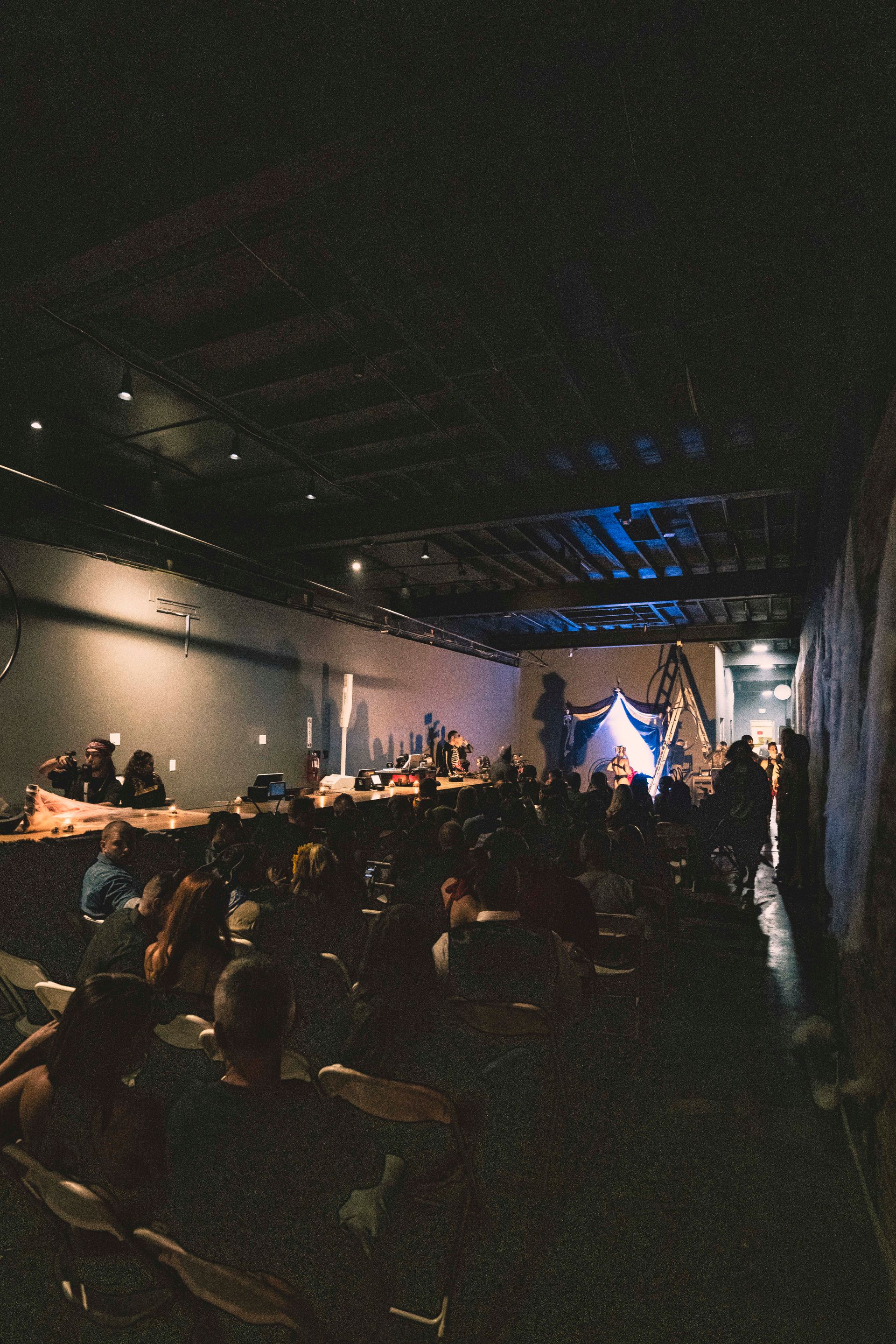 A group of people are sitting in a dark room watching a concert.