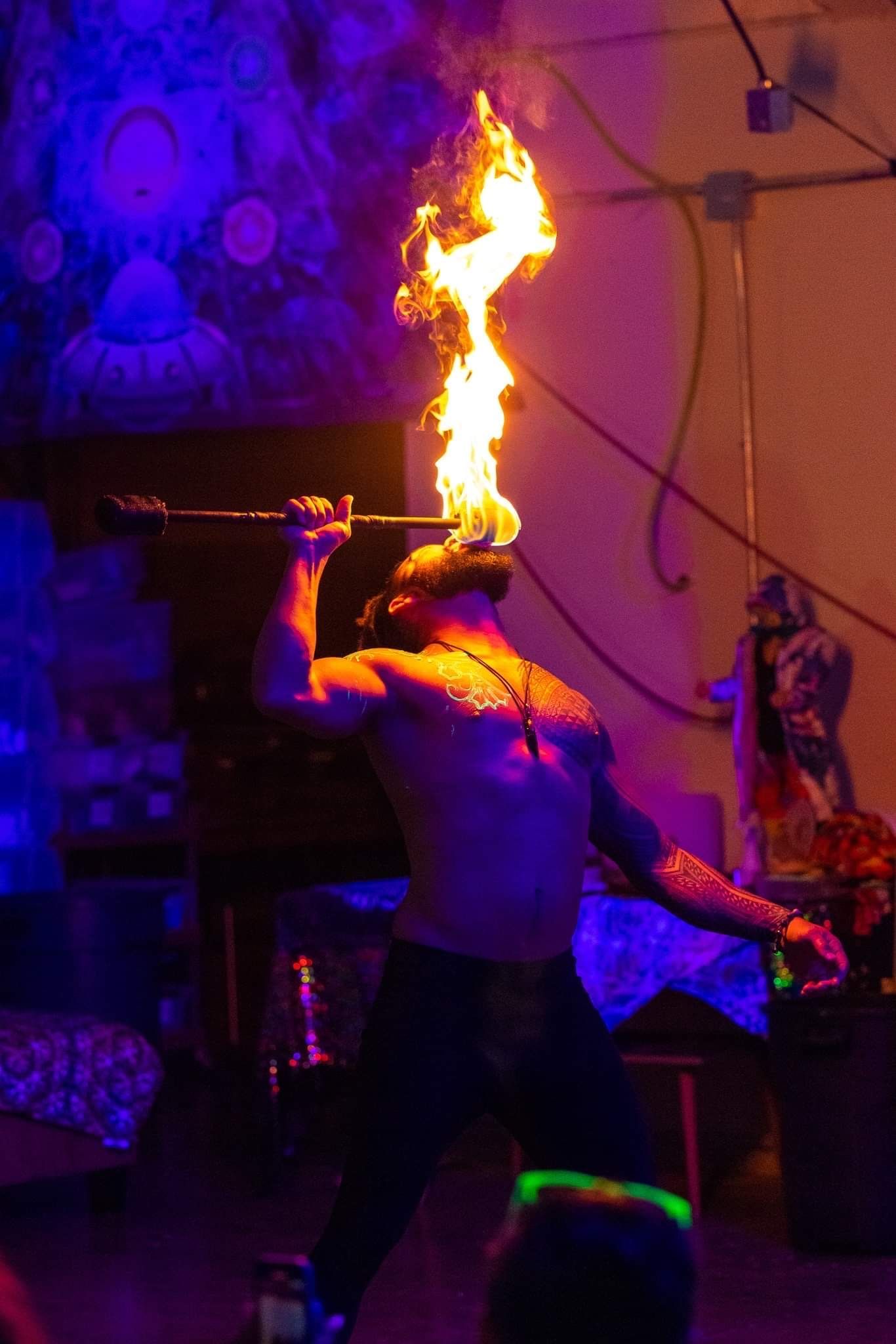 A man is holding a stick with flames coming out of it