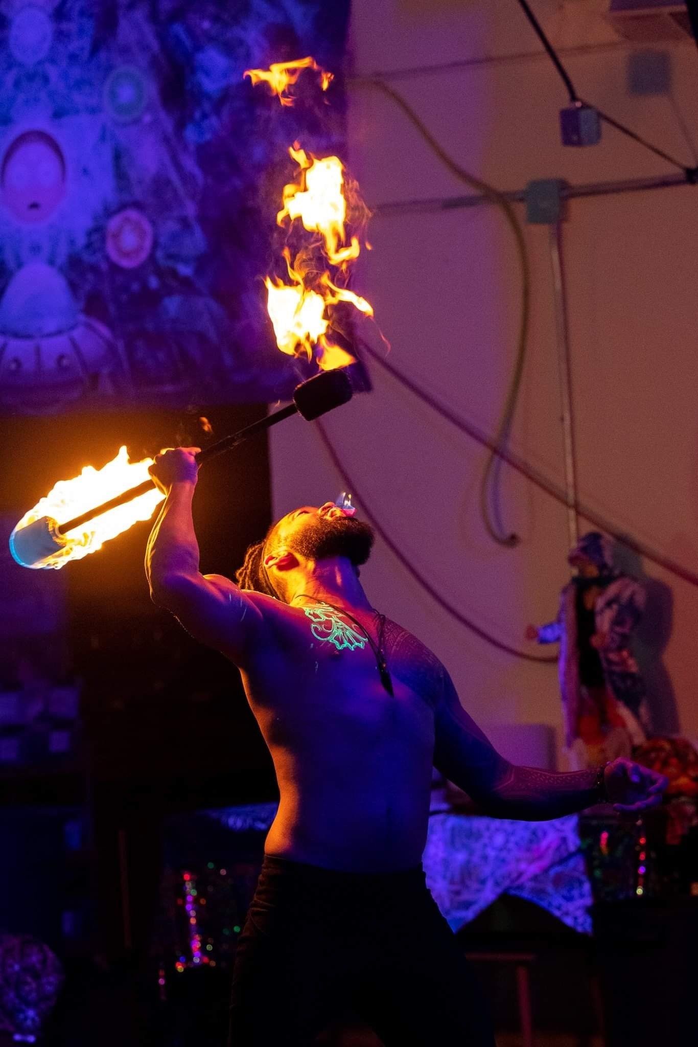 A man is holding a torch with flames coming out of it