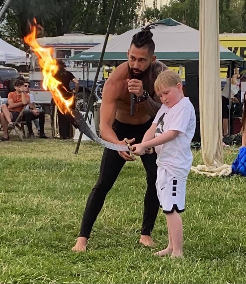 A man and a boy are playing with a fire torch