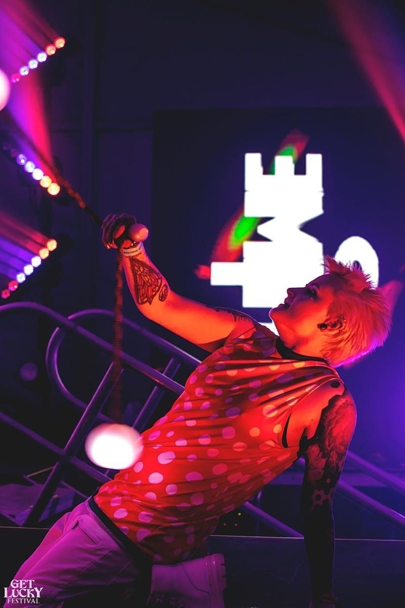 A man in a red shirt is singing into a microphone