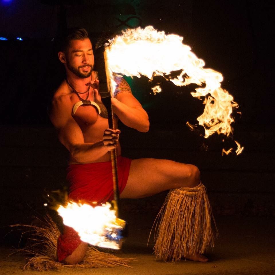 A man is holding a torch with flames coming out of it