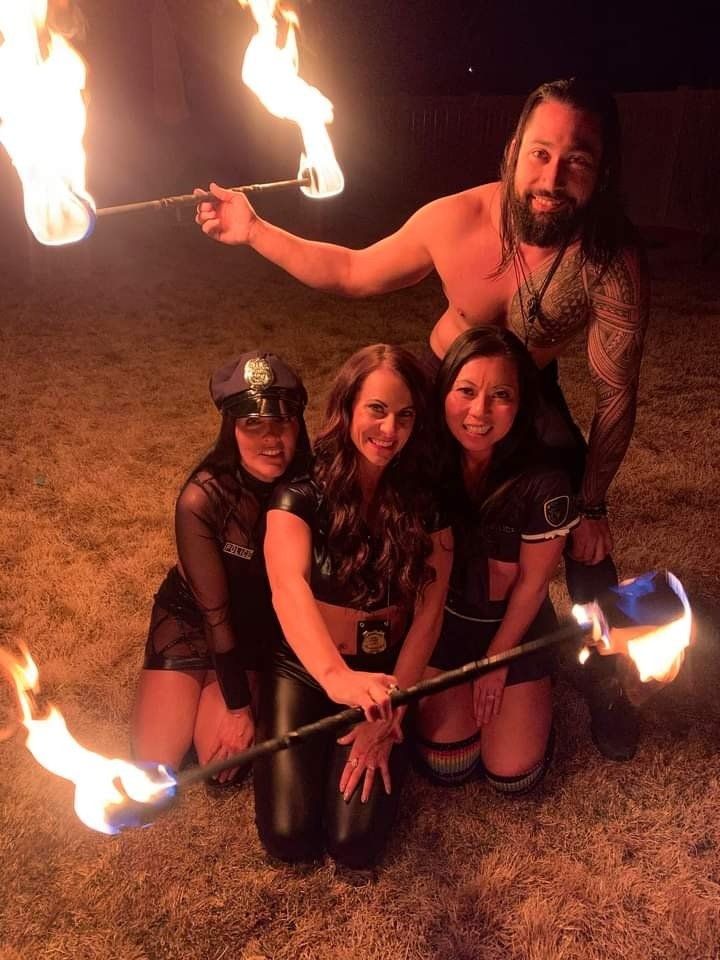 A group of people posing for a picture with fire sticks