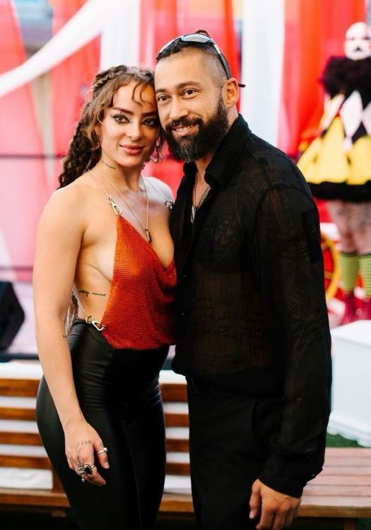 A man and a woman are standing next to each other on a bench.