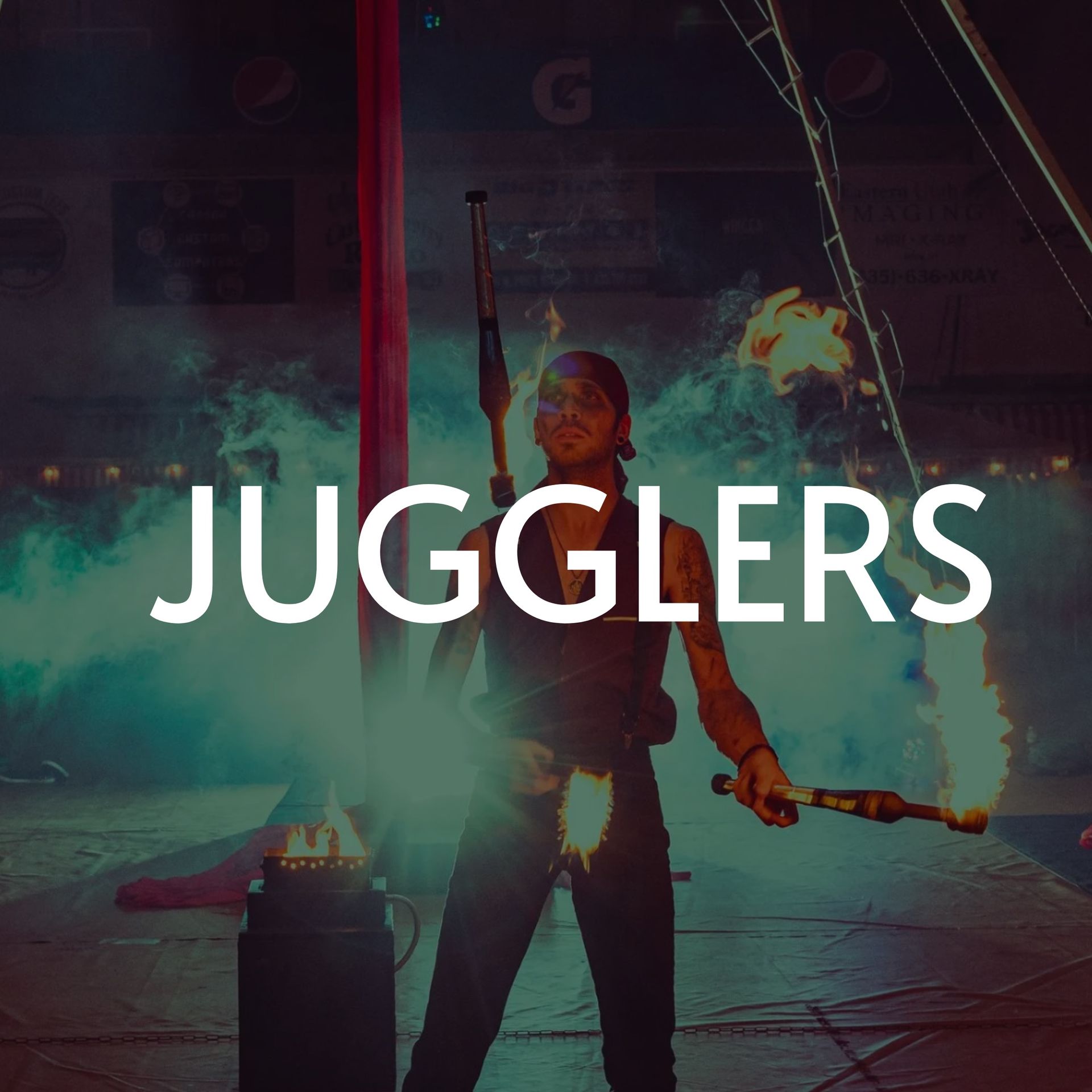 A juggler performing with flaming torches indoors, text 