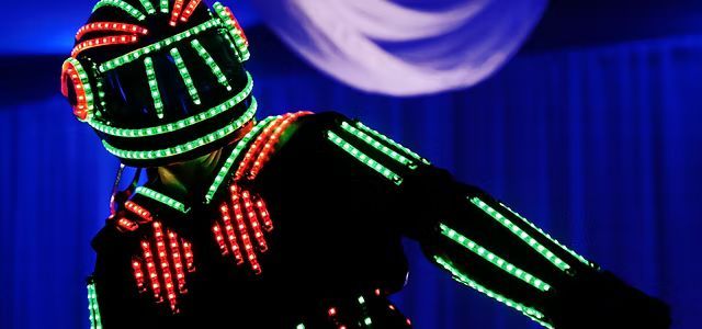 A person is wearing a helmet and a jacket with lights on them.